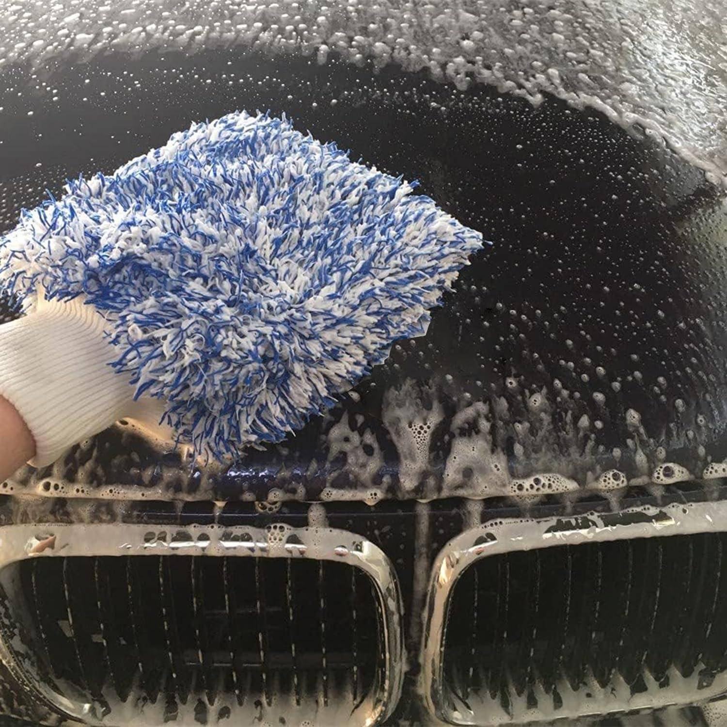 Hand mit Handschuh reinigt einen Autogrill mit einem seifigen Mikrofaser-Waschmittel während einer Autowäsche.