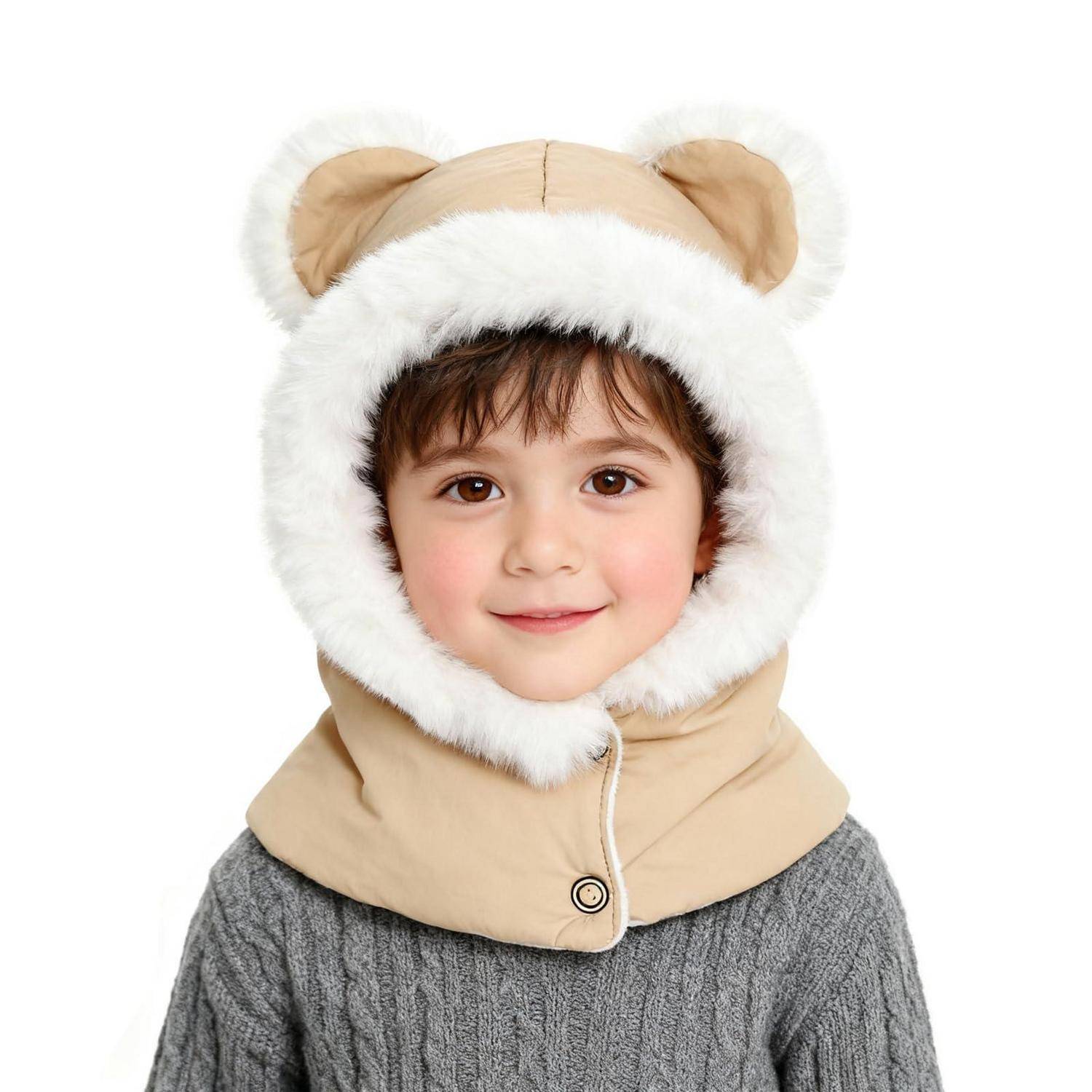 Kleines Kind, das eine beige, tierförmige Kapuze mit weißem Pelzbesatz und einen grauen Pullover trägt, lächelnd vor einem einfachen weißen Hintergrund.