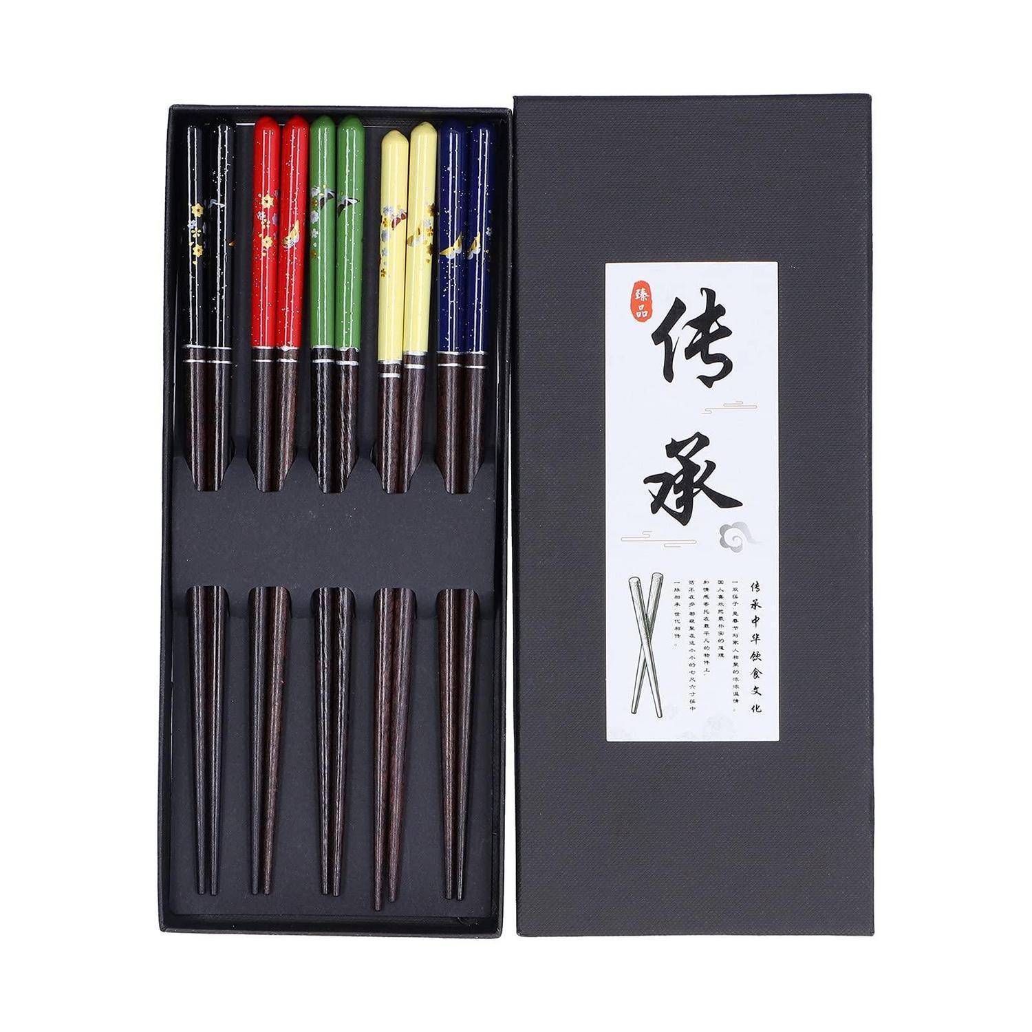 Offene schwarze Geschenkbox mit zwei Reihen farbenfroher und dunkeltoniger traditioneller Schreibpinsel, mit einem weißen Etikett mit chinesischen Zeichen auf dem Deckel.