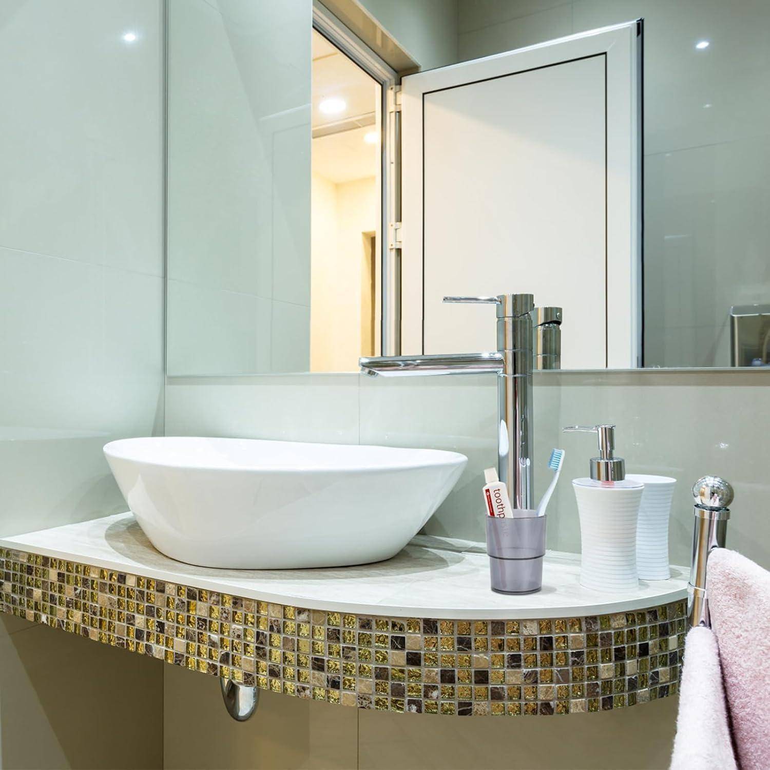 Modernes Badezimmerwaschtisch mit weißem Aufsatzwaschbecken, Chromarmatur, Spiegel und Zahnbürstenhalter auf einer Mosaikfliesen-Arbeitsplatte.