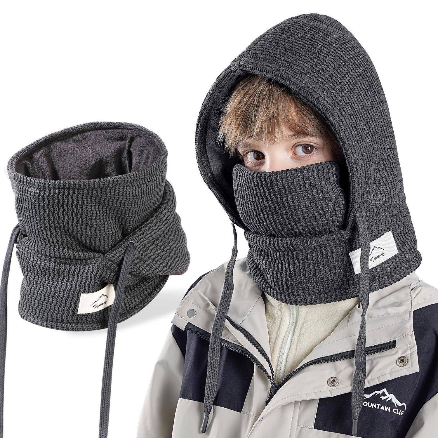 Kind mit dunkler grauer gestrickter Gesichtsmaske mit Kapuze und Nackenw ärmer; passendes Produkt daneben auf weißem Hintergrund dargestellt.