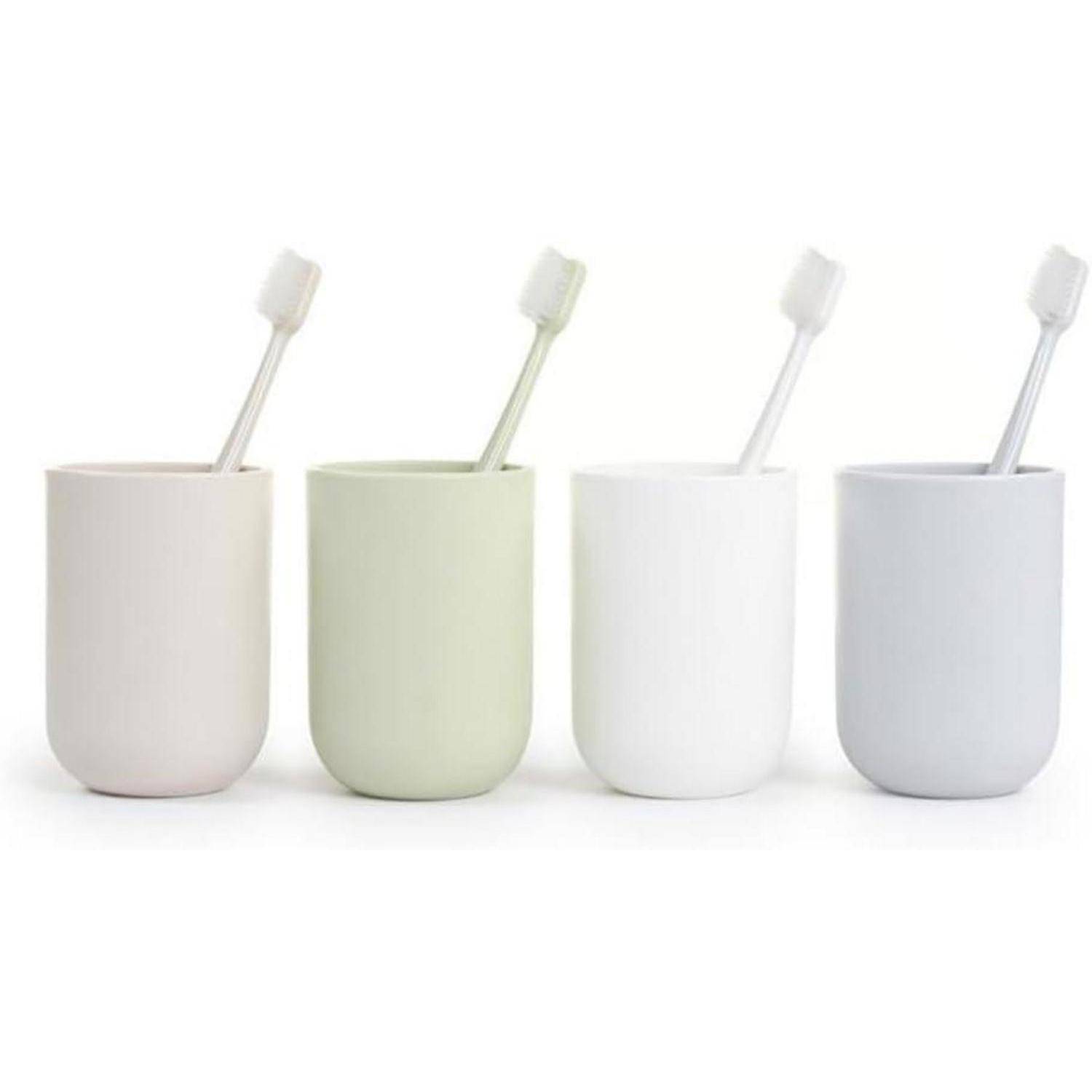 Vier minimalistische Zahnbürstenbecher in Beige, Blassgrün, Weiß und Hellgrau, jeweils mit einer Zahnbürste, auf weißem Hintergrund dargestellt.