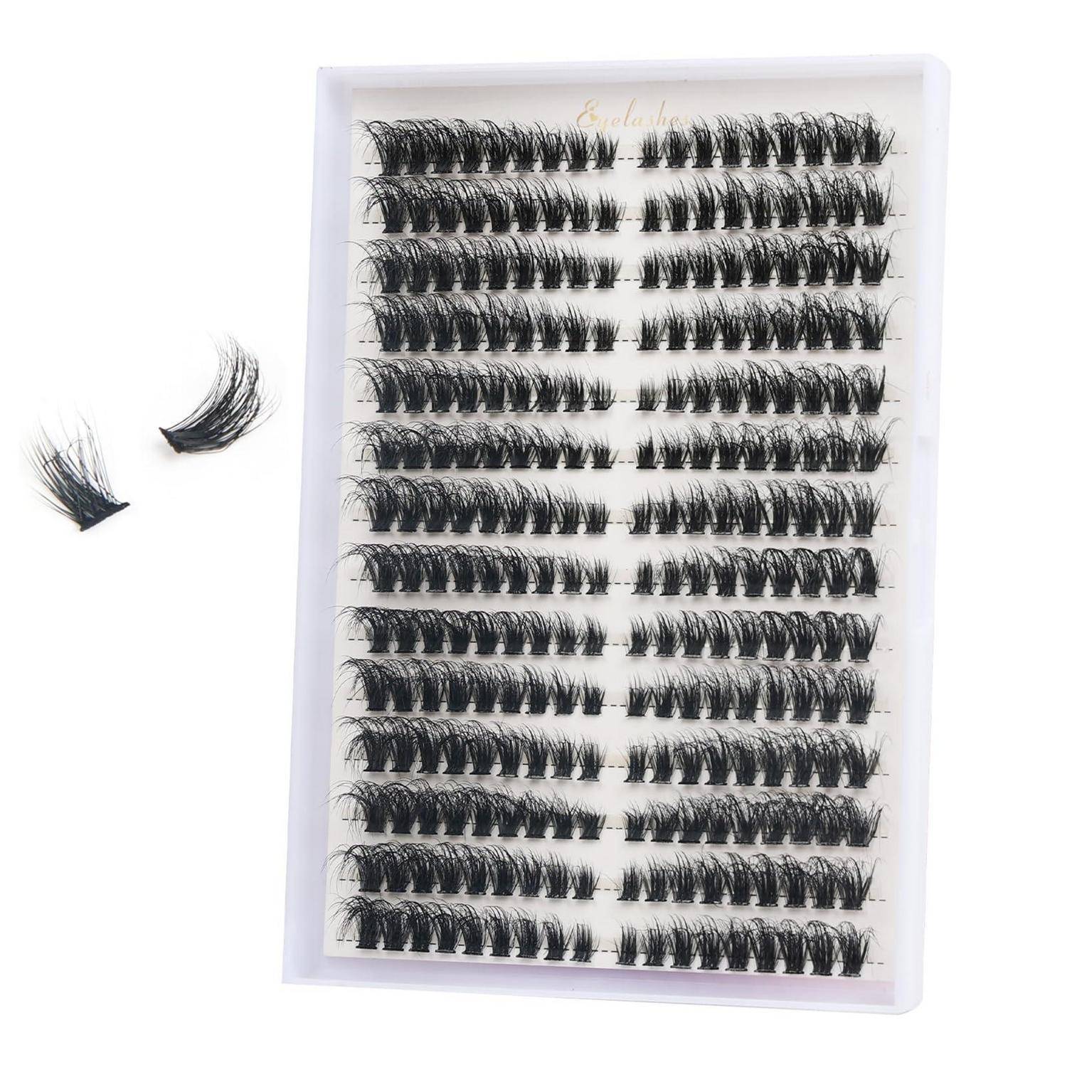 Verpackter Satz künstlicher Wimpern in einem durchsichtigen Tablett, mit zwei losen Wimpernbüscheln daneben.