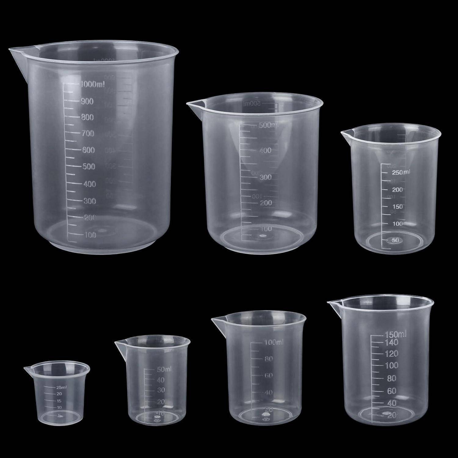Satz von sechs transparenten Kunststoff-Messbechern in verschiedenen Größen, mit Milliliter-Beschriftung, auf schwarzem Hintergrund angeordnet.