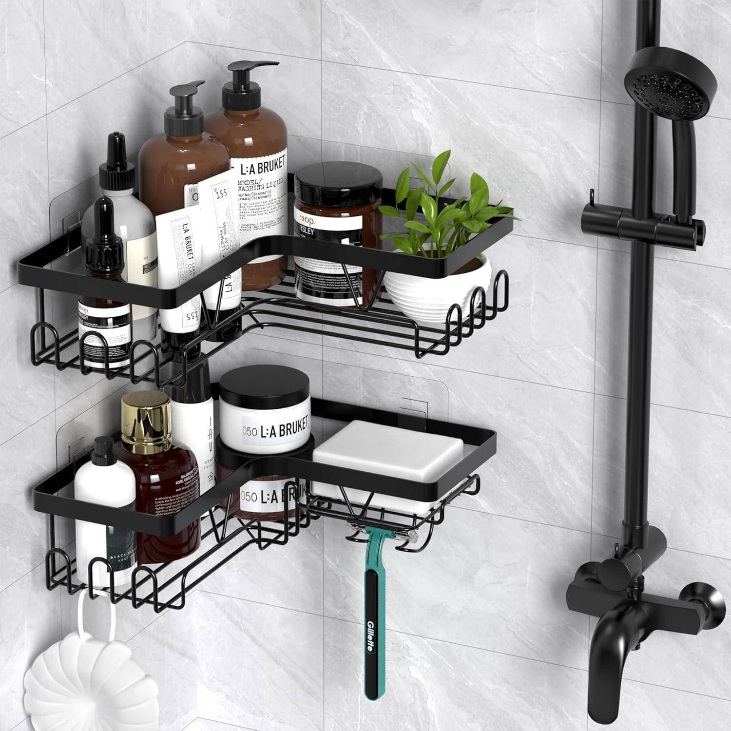 Schwarze Dusch-Caddy-Regale mit Toilettenartikeln, Seife, einem Rasierer und einer kleinen Pflanze neben einer mattschwarzen Dusche und einem Wasserhahn an einer gekachelten Wand.