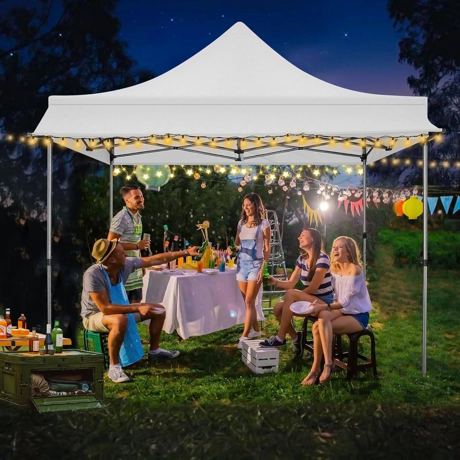 Freunde versammelten sich unter einem weißen Zeltdach bei einer Outdoor-Abendfeier, unterhielten sich und tranken an einem dekorierten Tisch mit Lichterketten.