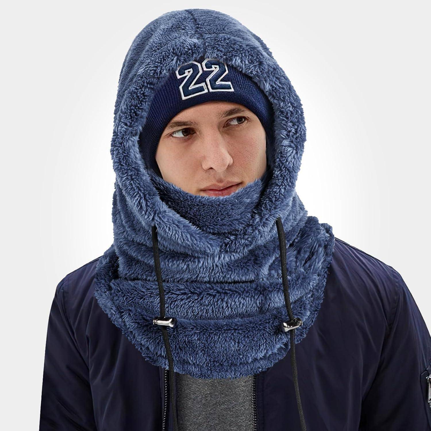 Person, die einen blauen flauschigen Kapuzenpulli und eine Gesichtsbedeckung mit einer dunkelblauen Mütze mit der Aufschrift „22