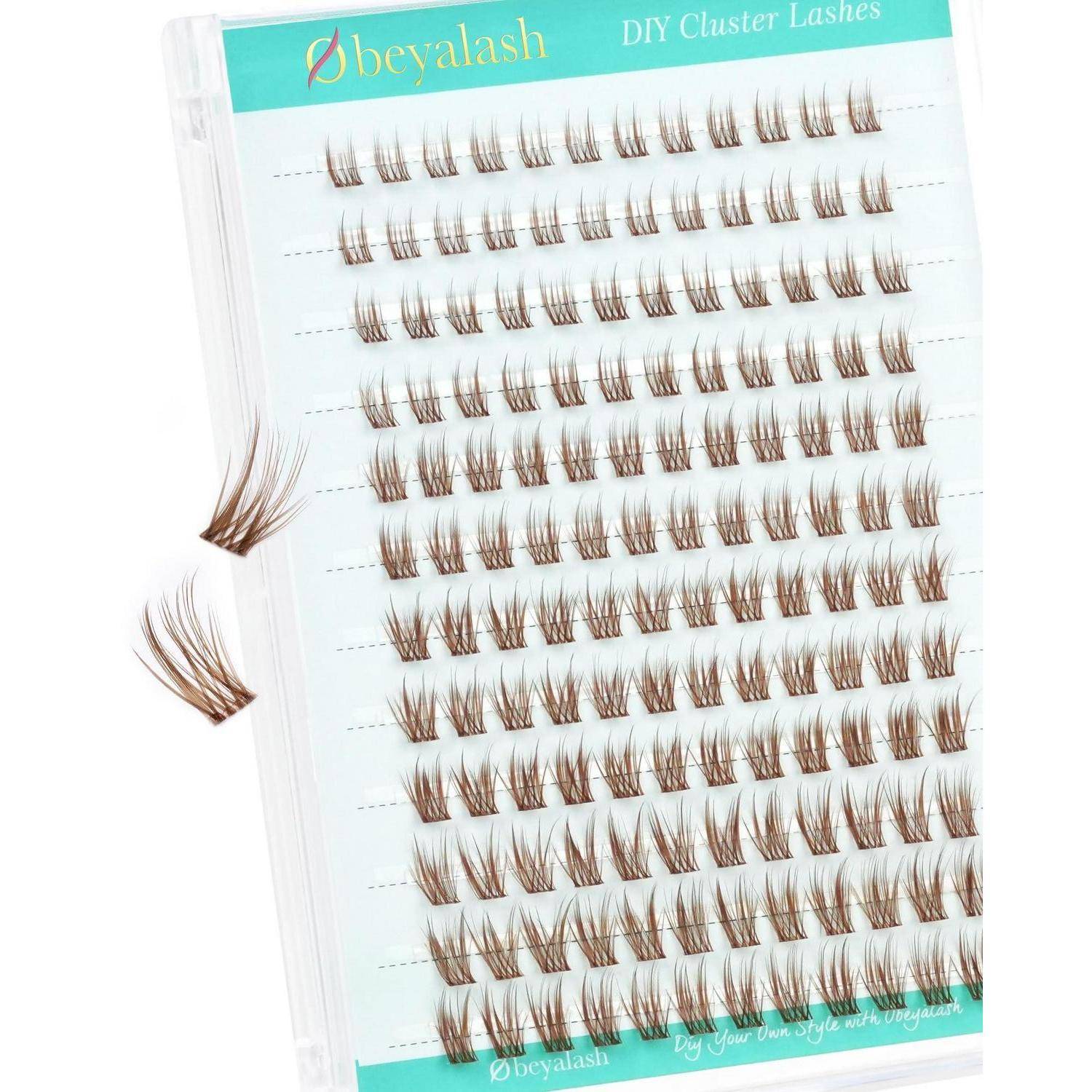 Packung mit Beyalash DIY Cluster Lashes auf einem Tablett, das Reihen von braunen falschen Wimpern-Clustern und zwei lose Wimpern-Fächer daneben zeigt.