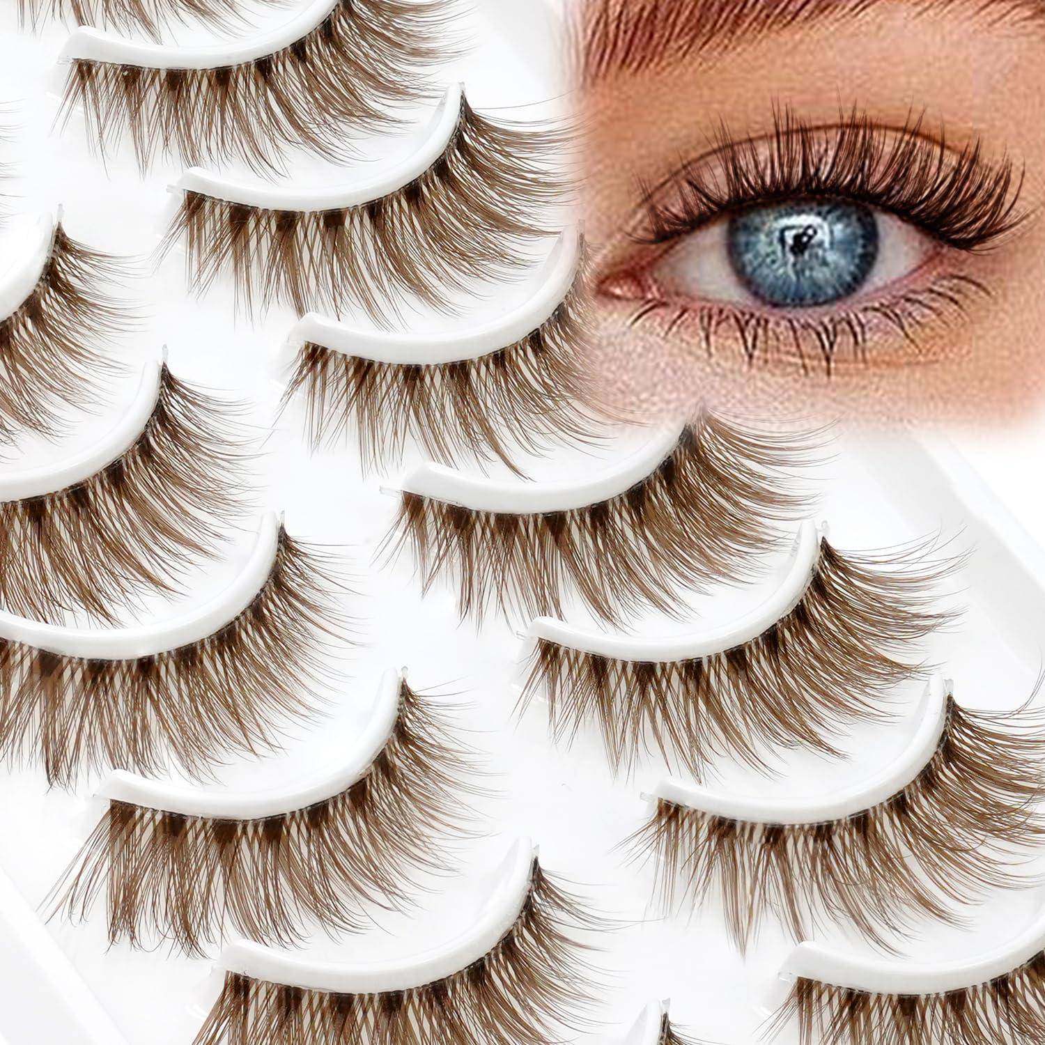 Nahaufnahme von mehreren falschen Wimpernstreifen in weißen Tabletts neben dem blauen Auge eines Models, die Wimpernverlängerungen oder kosmetische Wimpern zeigt.