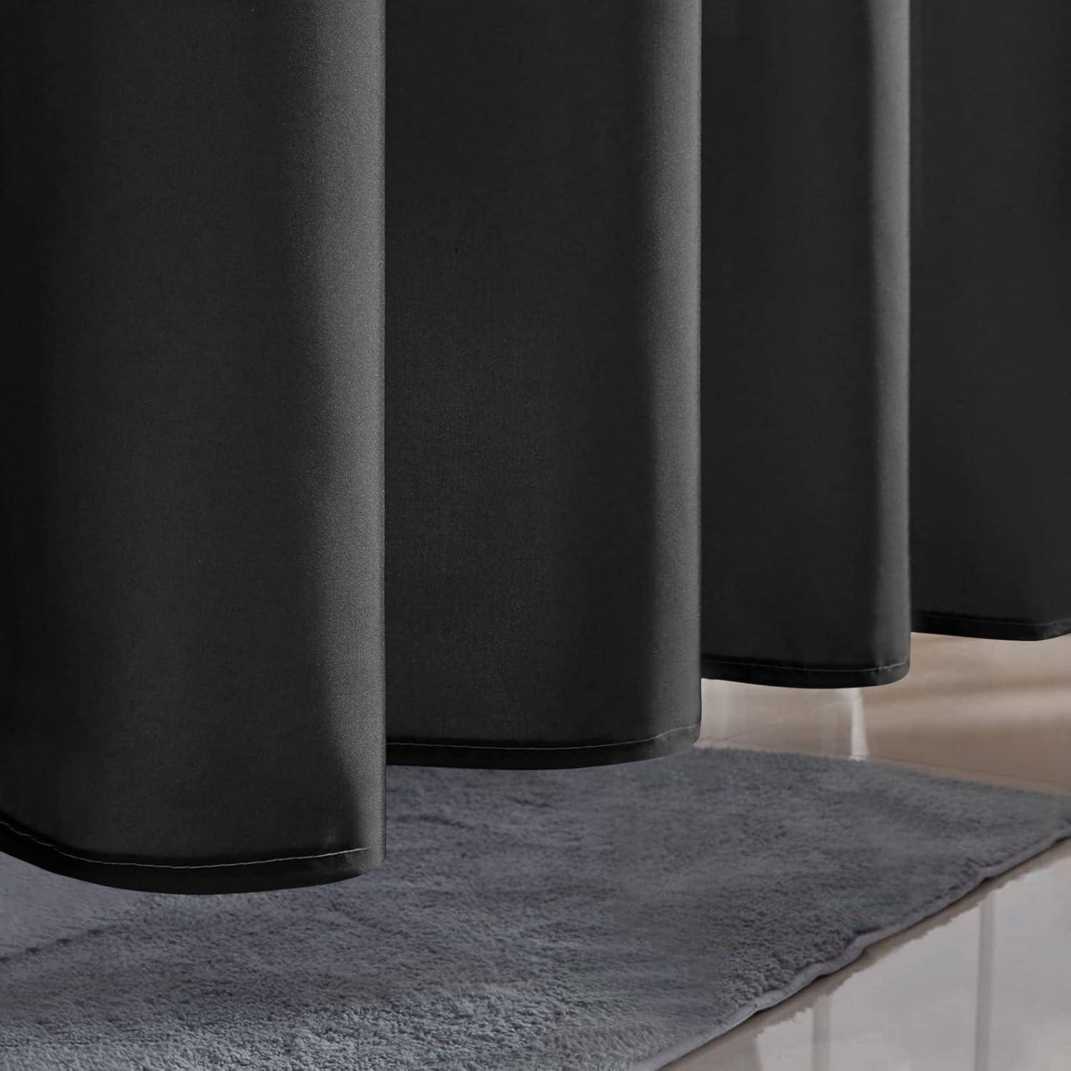 Schwarze bodenlange Vorhänge hängen über einem grauen Teppich auf einem hellen Boden und zeigen ein minimalistisches Inneneinrichtungsdetail.