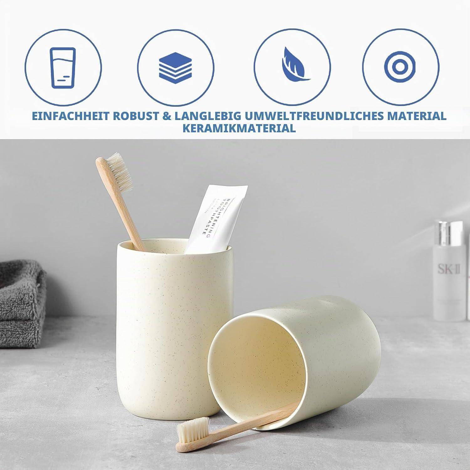 Foto von zwei beigen Keramikbechern, die im Badezimmer als Behälter für Zahnbürste und Zahnpasta verwendet werden, mit deutschem Text darüber: 'EINFACHHEIT ROBUST & LANGLEBIG UMWELTFREUNDLICHES MATERIAL KERAMIKMATERIAL'.