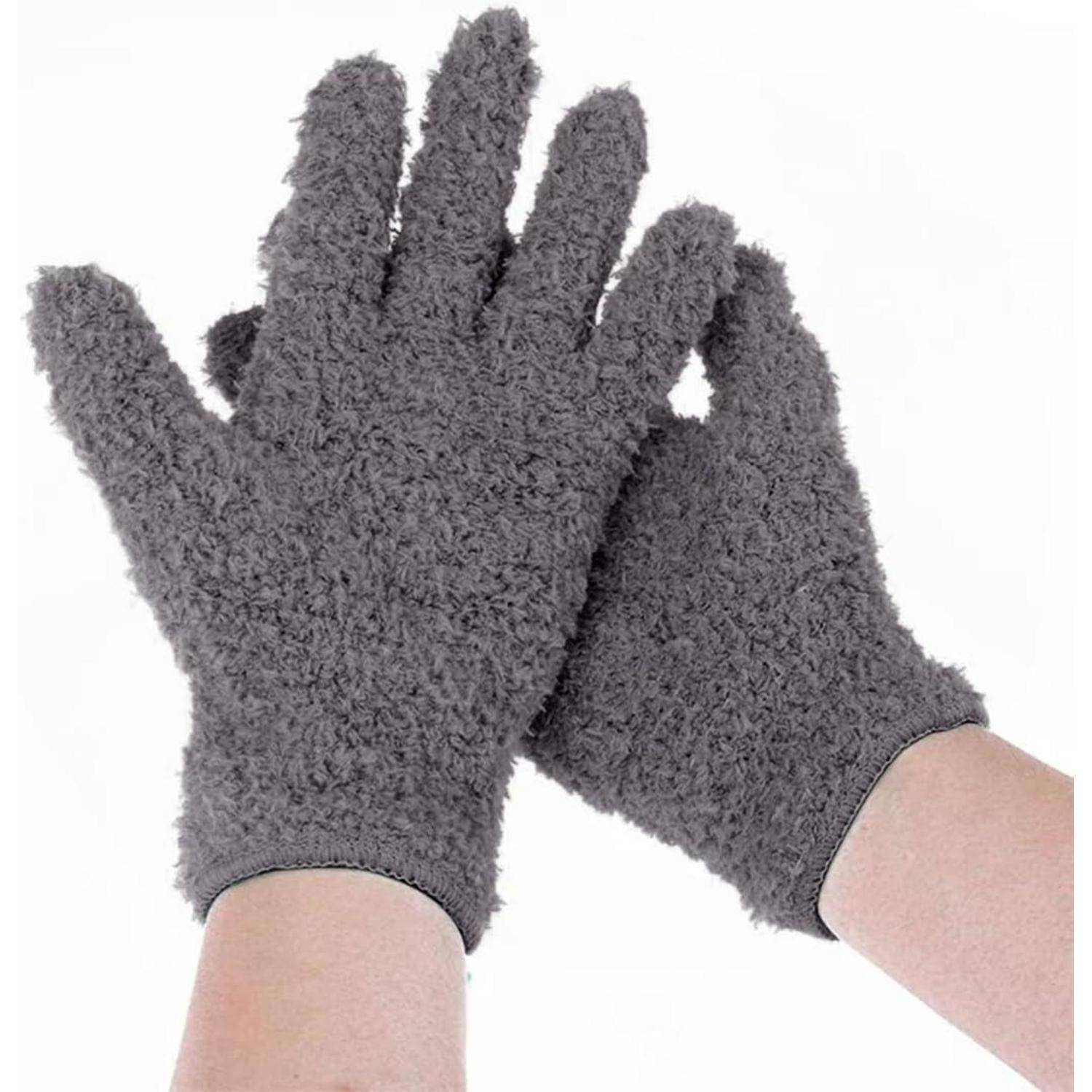 Paar grauer flauschiger Handschuhe an den Händen vor weißem Hintergrund.