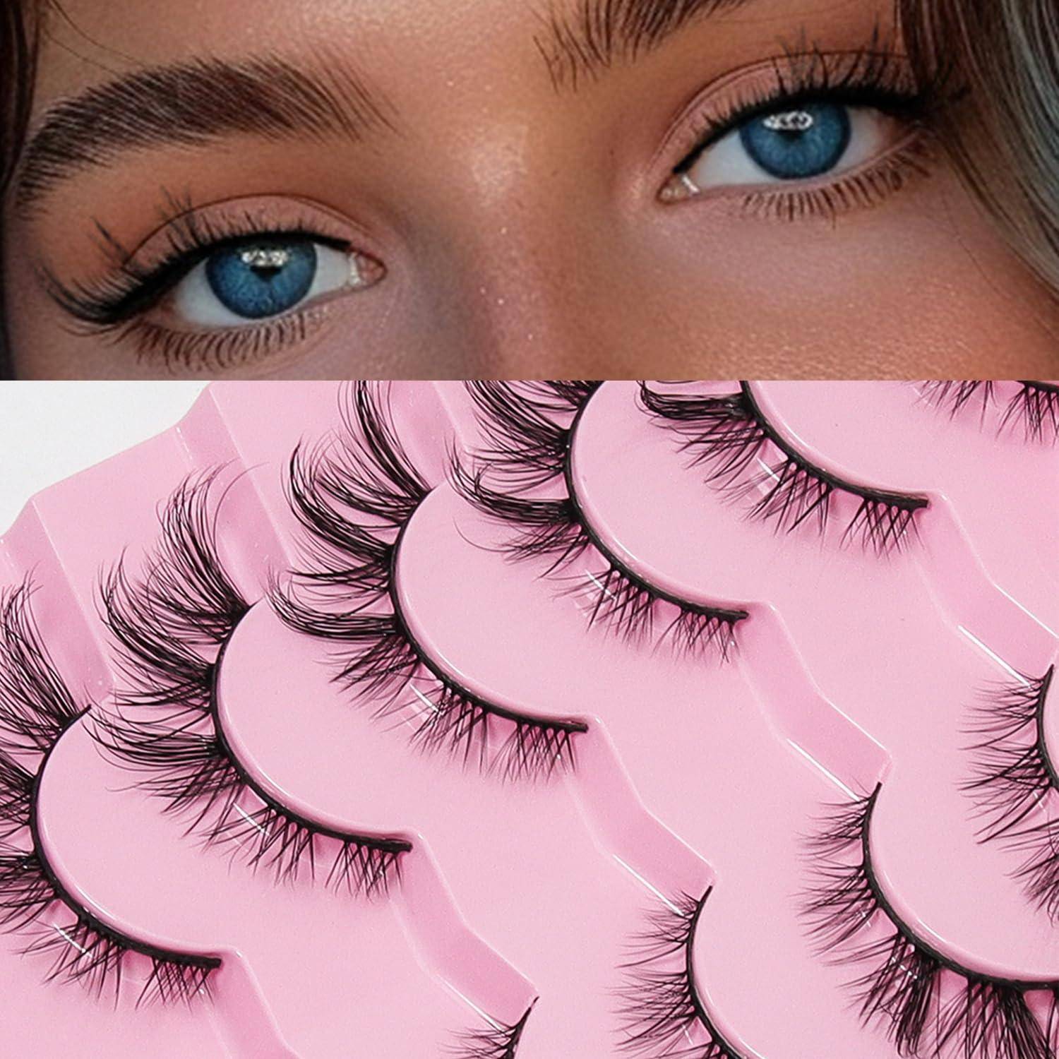 Nahaufnahme von blauen Augen mit langen Wimpern über einer Auswahl mehrerer falscher Wimpernpaare auf rosafarbener Verpackung, was Schönheits-Make-up-Produkte andeutet.
