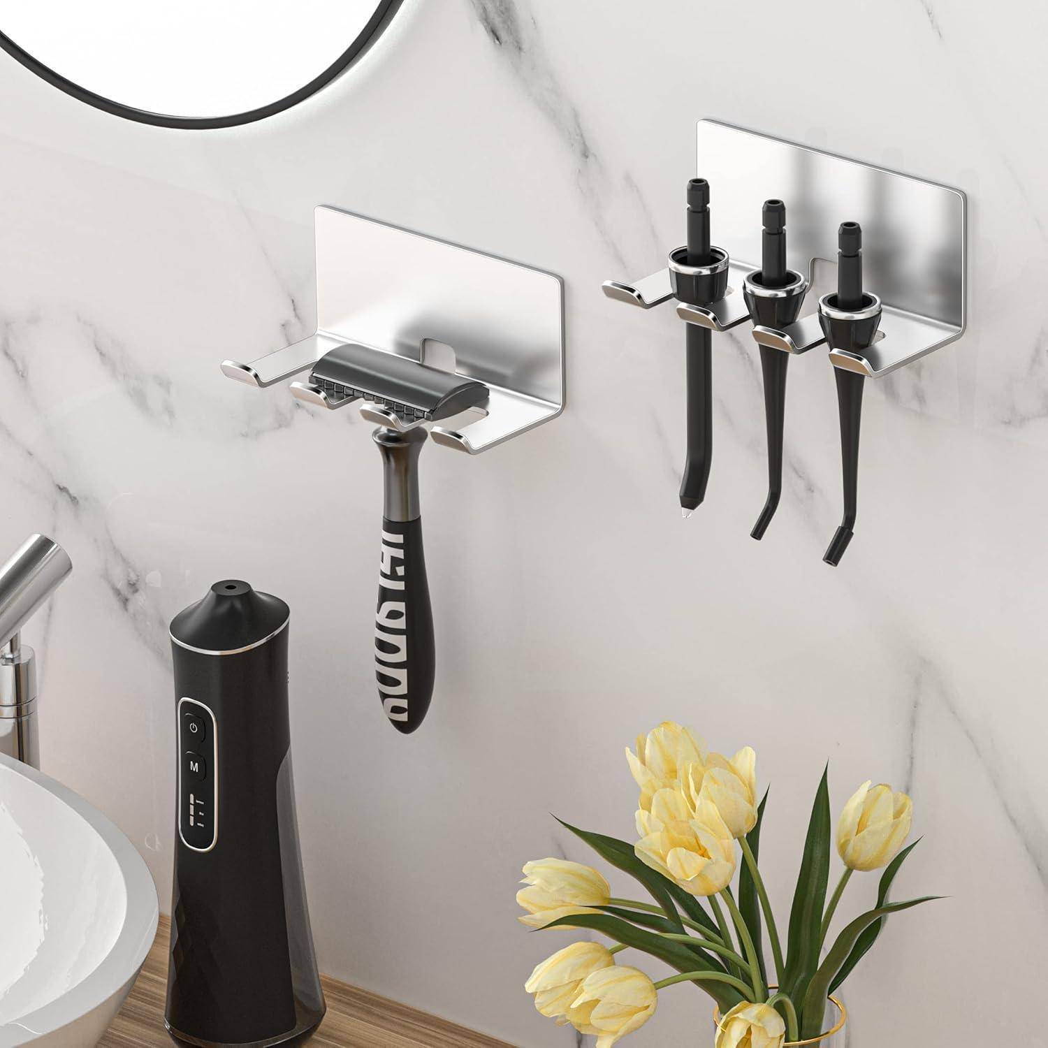 An der Wand montierte Badezimmerorganizer halten einen Rasierer und drei Zahnbürsten neben einem Waschbecken, mit einer schwarzen elektrischen Zahnbürste und gelben Blumen auf der Arbeitsplatte.