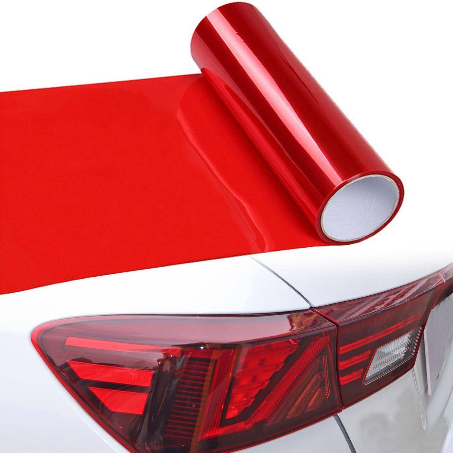 Rote Vinyl-Folie wird auf der Rückseite eines weißen Autos in der Nähe des Rücklichts angebracht.