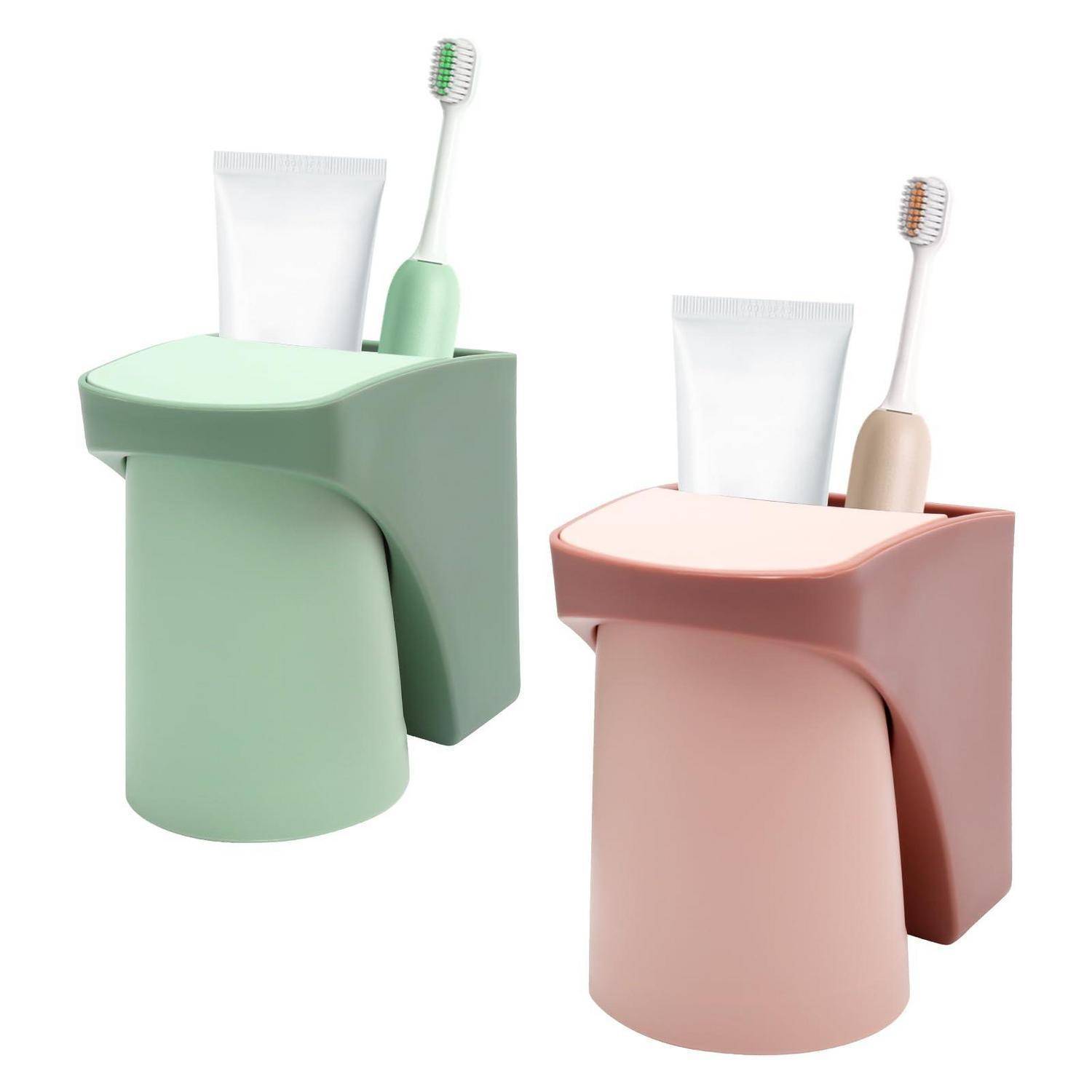 Zwei an der Wand montierte Badezimmerorganizer, einer in Mintgrün und einer in Blush-Rosa, jeder mit einer Zahnpastatube und einer Zahnbürste vor weißem Hintergrund.