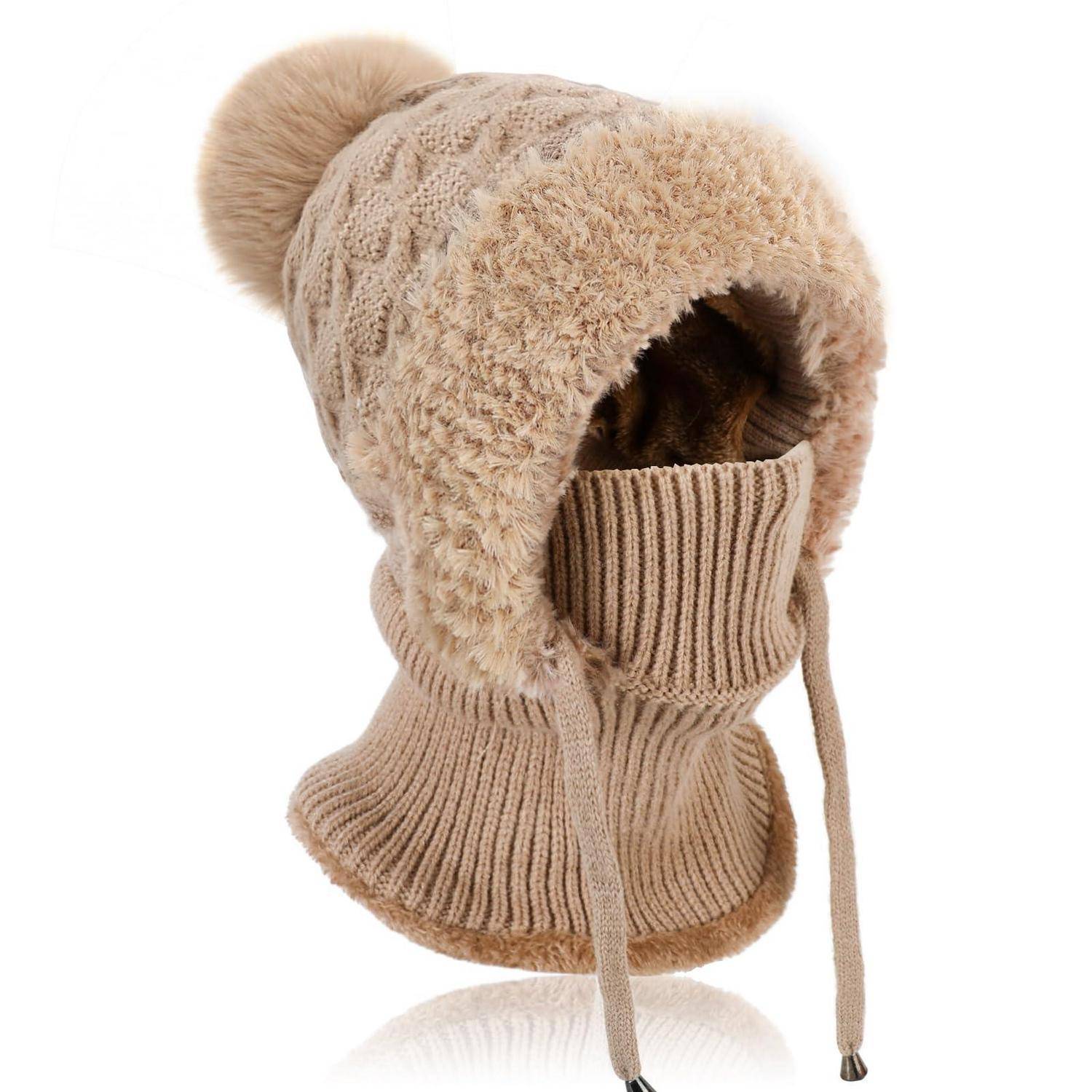 Beige gestrickte Wintermütze mit flauschiger Ohrenklappe, Bommel und Kinnbändern, isoliert auf weißem Hintergrund.