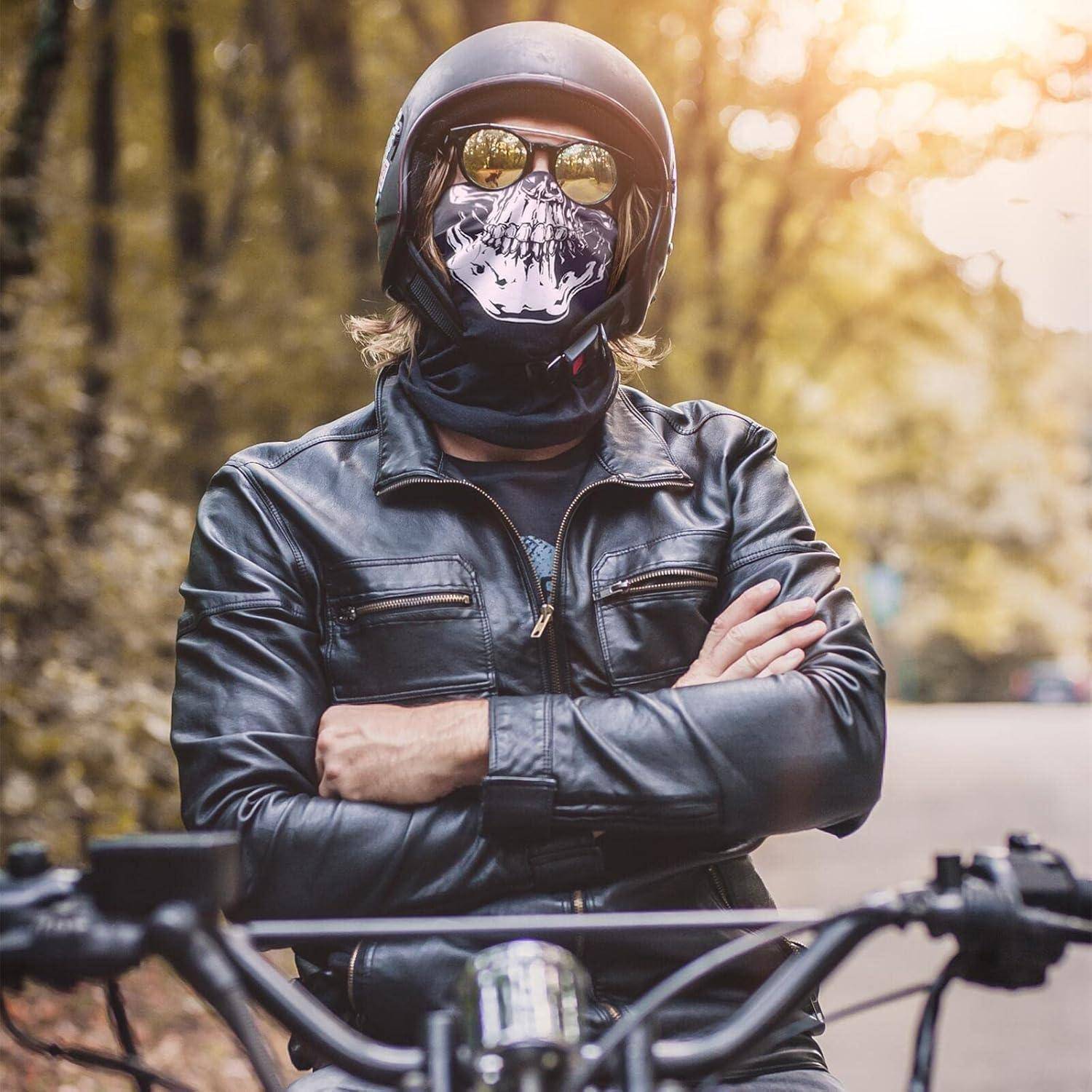 Person mit Motorradhelm, Totenkopf-Gesichtsmaske, verspiegelten Sonnenbrillen und schwarzer Lederjacke steht mit verschränkten Armen hinter Motorradlenkstangen.