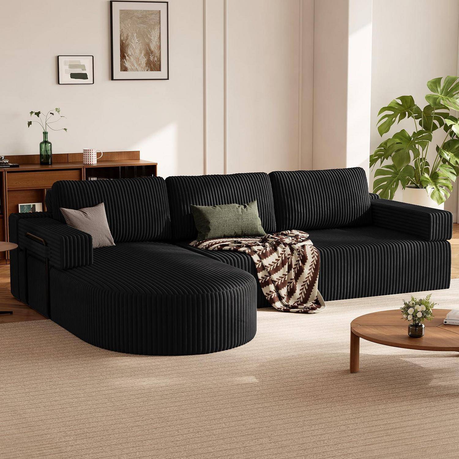 Modernes Wohnzimmer mit einem schwarzen geriffelten Ecksofa, Holz-Couchtisch, Pflanze und rahmendem Wandkunstwerk bei sanftem natürlichem Licht.