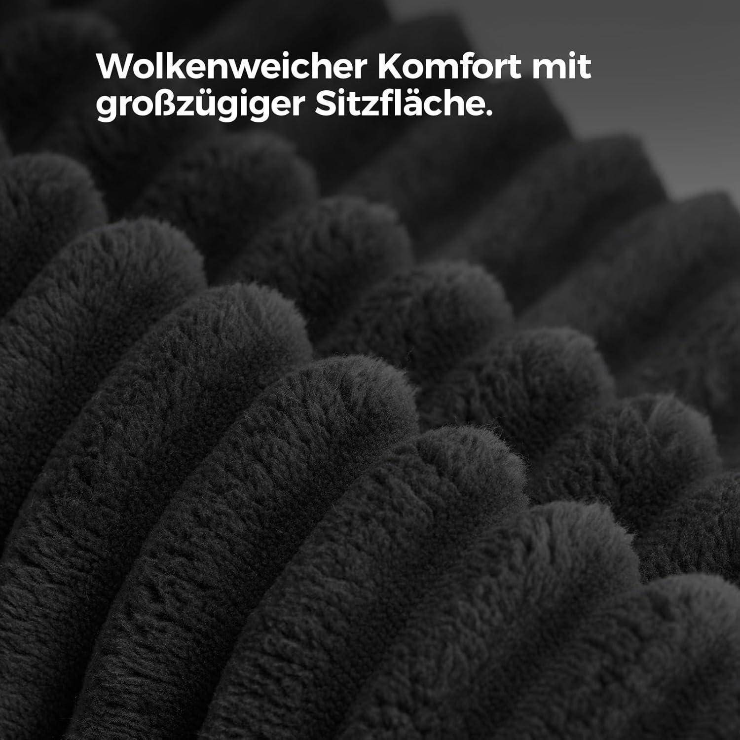 Nahaufnahme von schwarzen, flauschigen Stofffalten mit dem deutschen Text „Wolkenweicher Komfort mit großzügiger Sitzfläche.