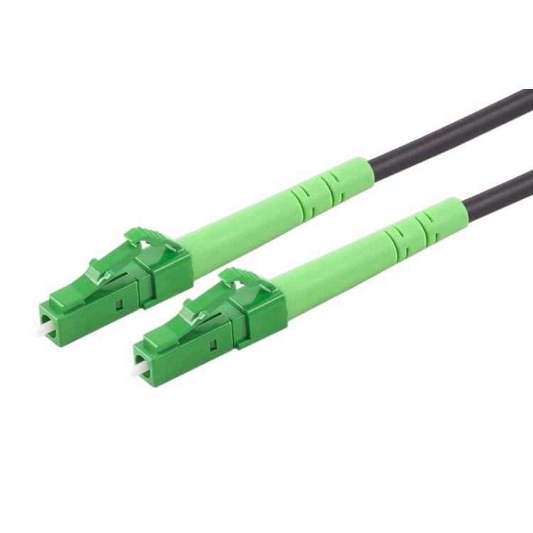 Zwei grüne Lichtwellenleiterkabelstecker, die an schwarzen Kabeln auf weißem Hintergrund befestigt sind.