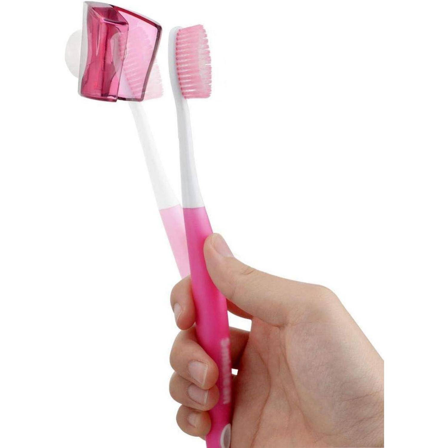 Hand, die eine rosa Zahnbürste mit integriertem Zahnpastaspender und Kappe auf weißem Hintergrund hält.