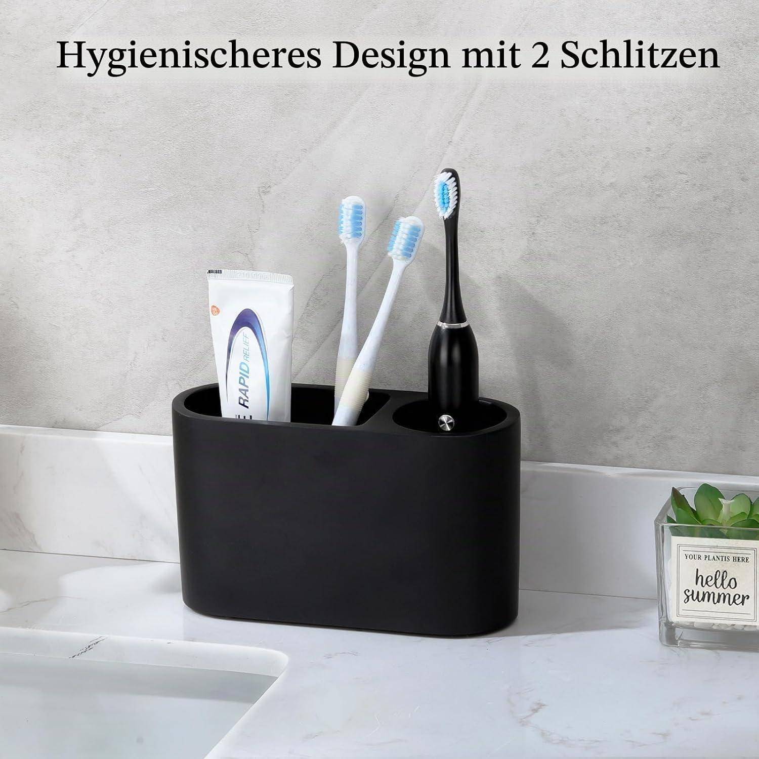 Schwarzer Zahnbürstenhalter für die Arbeitsplatte mit zwei Fächern und einer Zahnpastatube, die drei Zahnbürsten neben einem Badezimmerbecken hält.