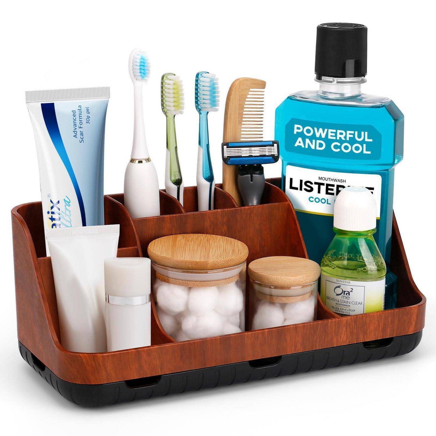 Badezimmer-Arbeitsplatte-Organizer, der Zahnpasta, Zahnbürsten, Kamm, Rasierer, Mundwasser und kleine Toilettenartikelgläser in einem Holztablett hält.