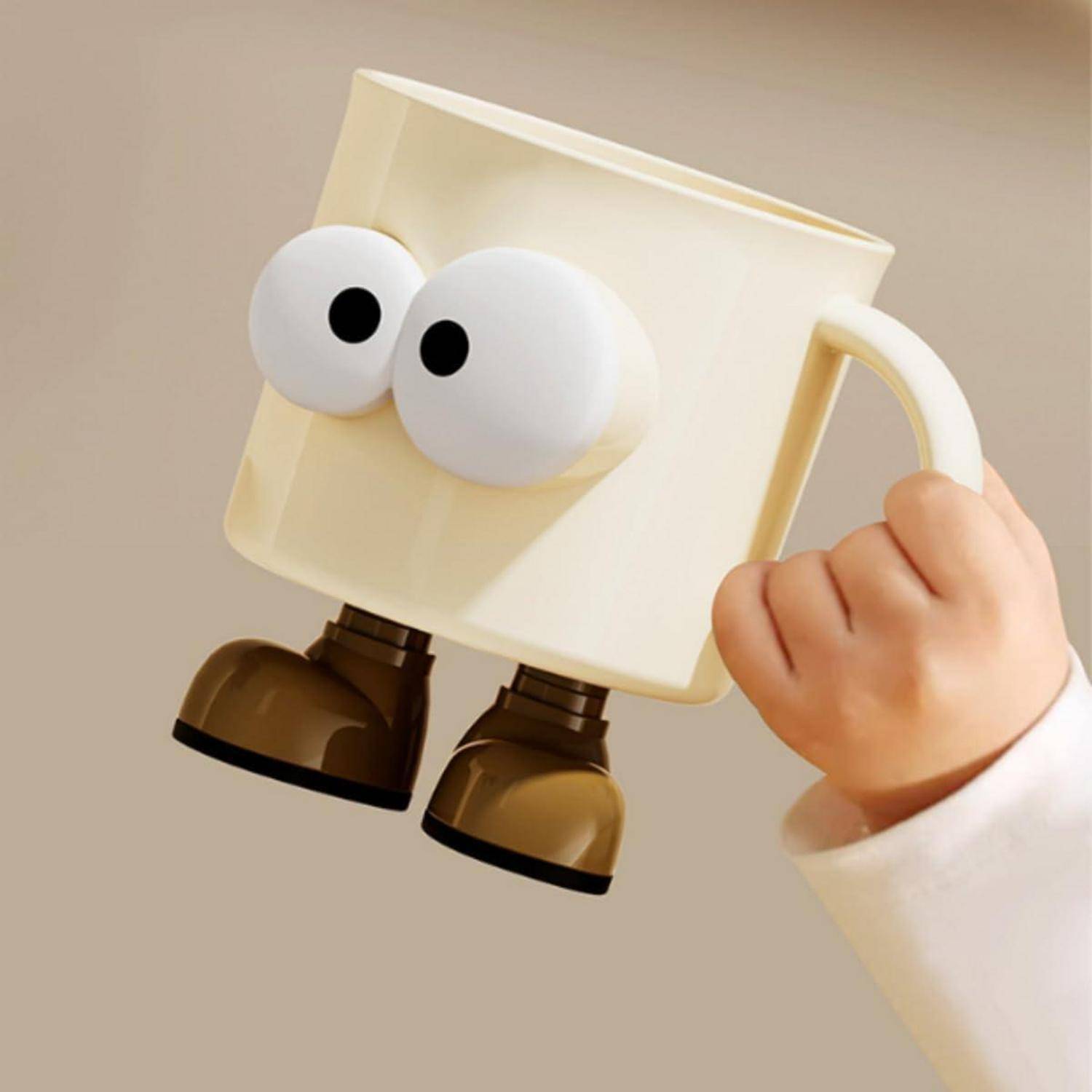 Cartoon-Becher-Charakter mit großen Augen und Stiefeln, von einer Hand gegen einen einfachen beigen Hintergrund hochgehalten.