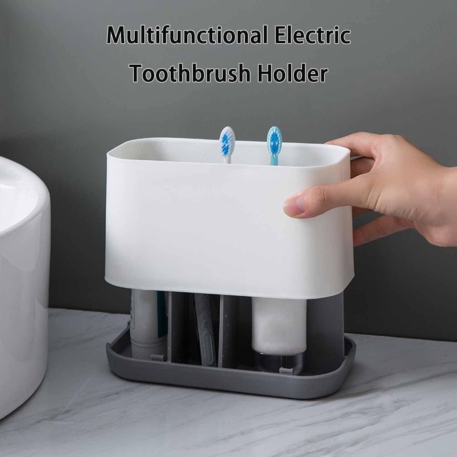 Weißer multifunktionaler Zahnbürstenhalter aus Kunststoff mit Plätzen für zwei elektrische Zahnbürsten und Fächern am Boden, gezeigt, wie er auf einem Badezimmertisch gehalten wird.