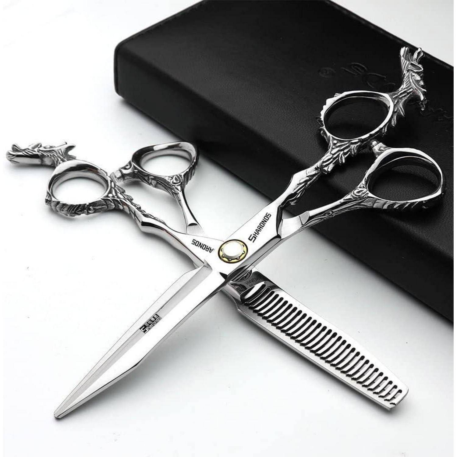 Dekorative Silberhaarschneidescheren mit verzierten Griffen und einem angebrachten Kamm, ausgestellt in einem schwarzen Etui.