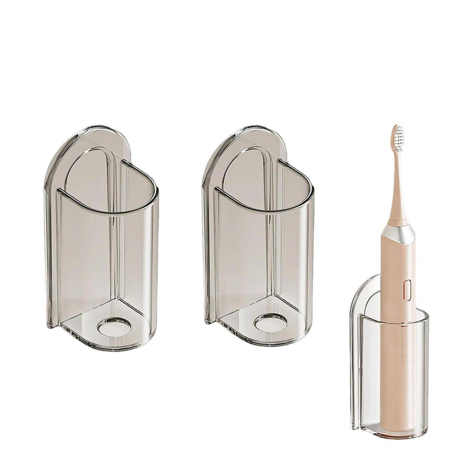 Drei wandmontierte, durchsichtige Halter, von denen einer eine beige elektrische Zahnbürste hält, auf weißem Hintergrund gezeigt.