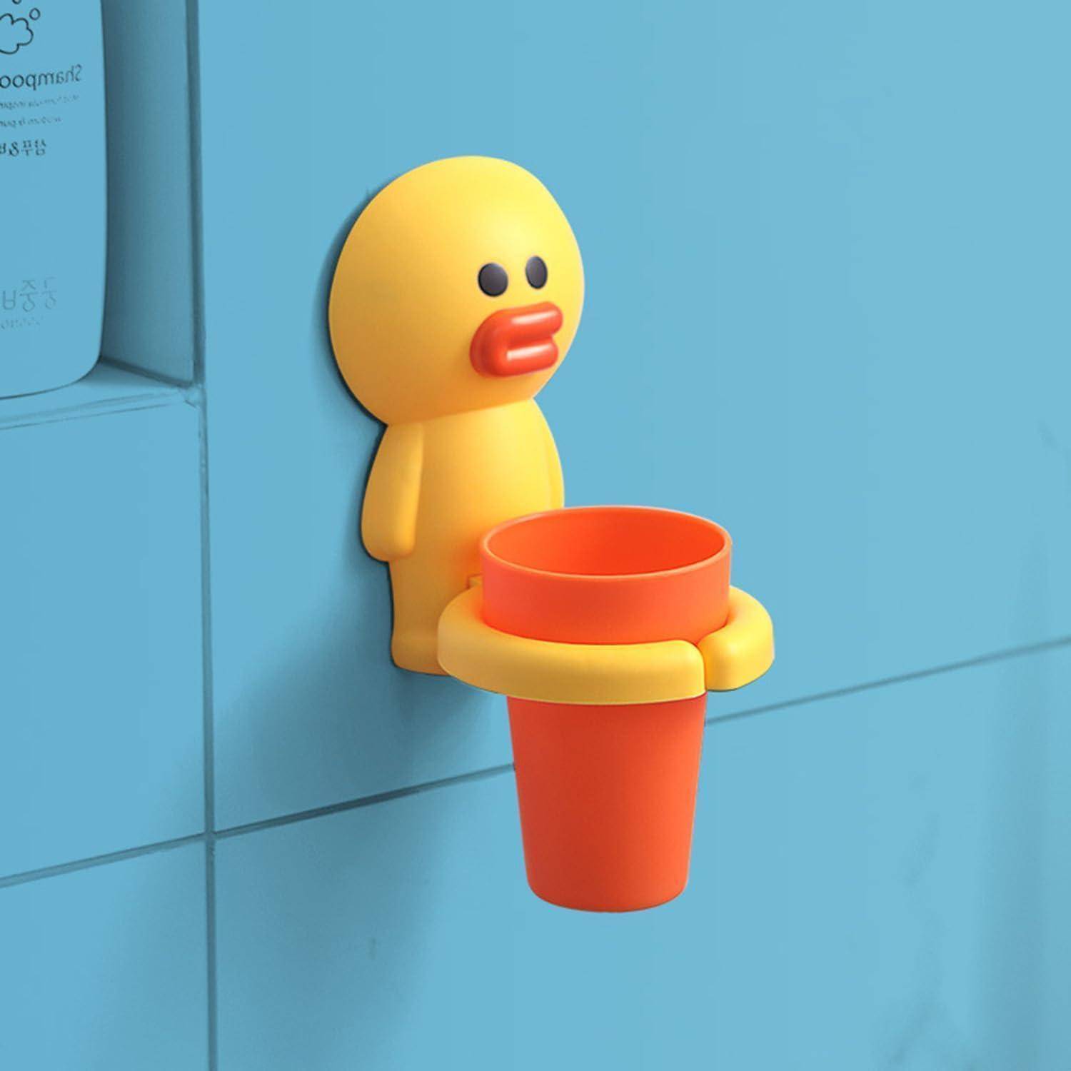 Gelbe Spielzeugentenfigur an einer blauen Wand befestigt, die einen orangefarbenen Becher oder Halter hält.