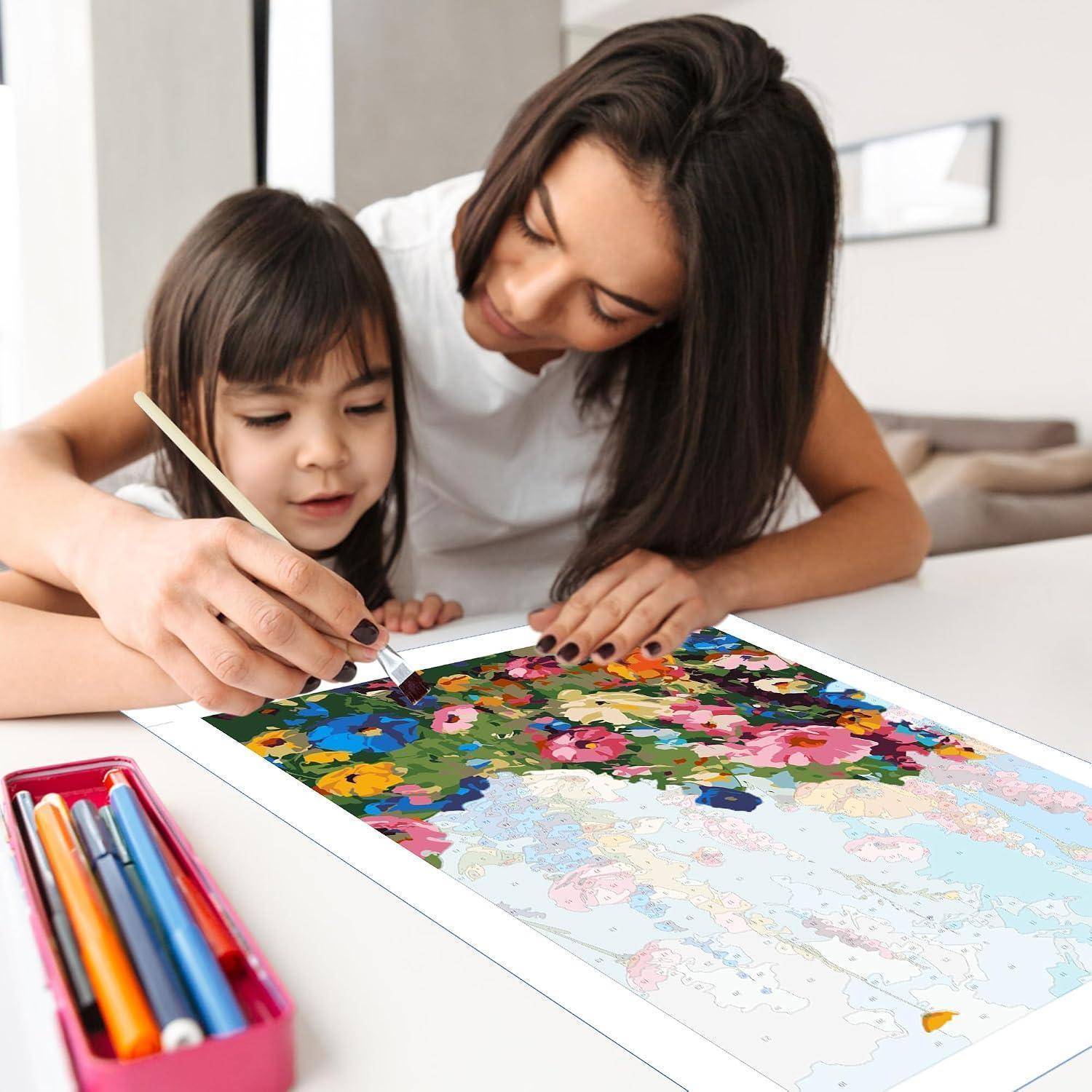 Mutter hilft einem jungen Mädchen, ein buntes Kartenpuzzle auf einem Tisch zu bemalen, mit Kunstbedarf in der Nähe.