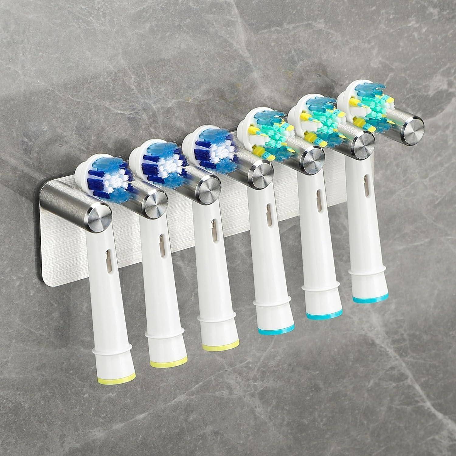 Sechs elektrische Zahnbürsten auf einem wandmontierten Ständer gelagert, mit blauen und mehrfarbigen Bürstenköpfen und weißen Griffen.