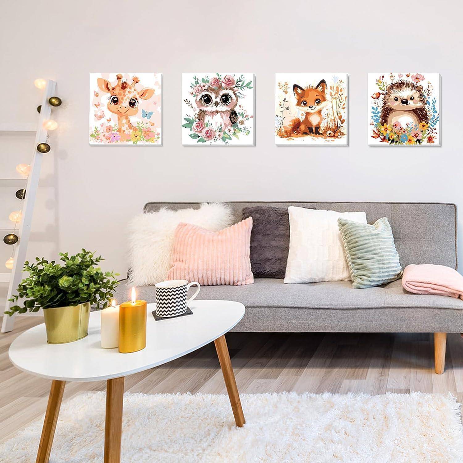 Gemütliches modernes Wohnzimmer mit grauem Sofa, Pastellkissen, weißem Couchtisch, Pflanze und Kerzen sowie vier süßen Tier-Wanddrucken über dem Sofa.