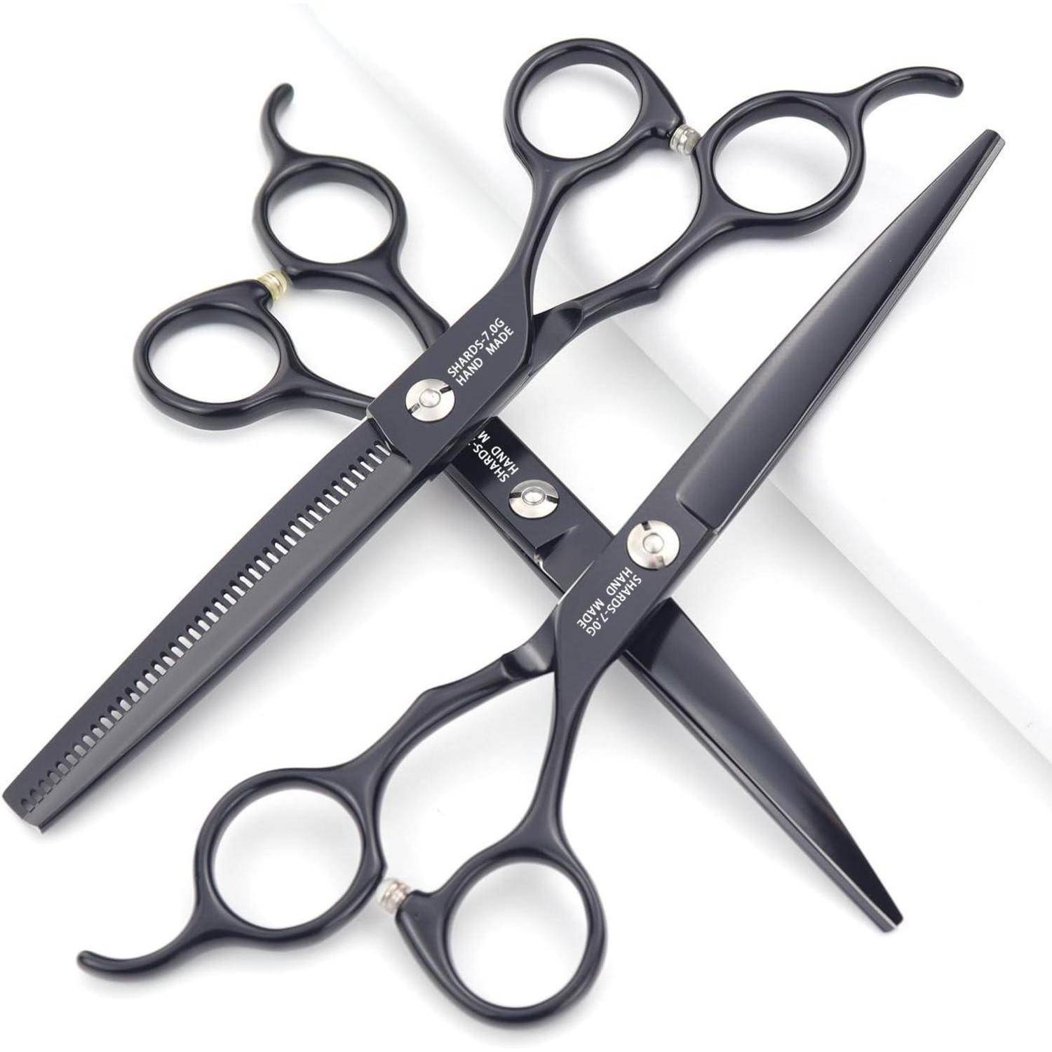 Zwei schwarze Haarschneidescheren, die sich auf weißem Hintergrund kreuzen, eine mit einer gezahnten Klinge und eine mit einer spitzen Klinge.