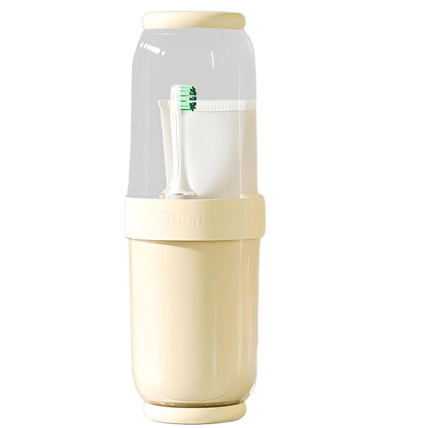 Tragbarer Mixer mit klarem oberem Behälter, der einen weißen Bürstenaufsatz enthält, und cremefarbener Basis auf weißem Hintergrund.