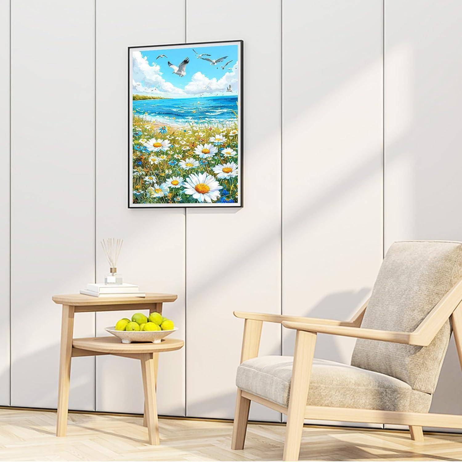Gerahmtes Seelandschaftsgemälde mit Gänseblümchen und Möwen über einem modernen Holzstuhl und einem Beistelltisch in einem hellen minimalistischen Raum.