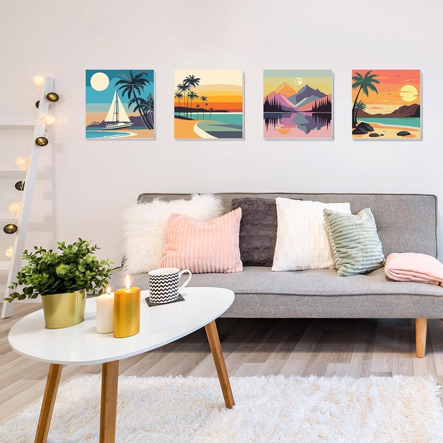 Gemütliches Wohnzimmer mit grauem Sofa, pastellfarbigen Kissen, Couchtisch mit Pflanze und Kerzen sowie vier tropischen Landschaftsdrucken an der Wand.
