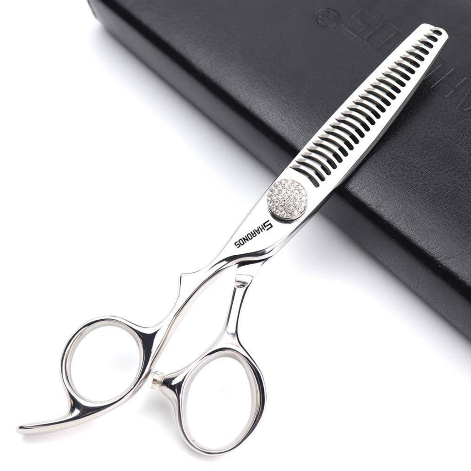 Silberne Ausdünnungsschere mit Fingerösen und kammartiger gezahnter Klinge, ruhend auf einem schwarzen Etui.