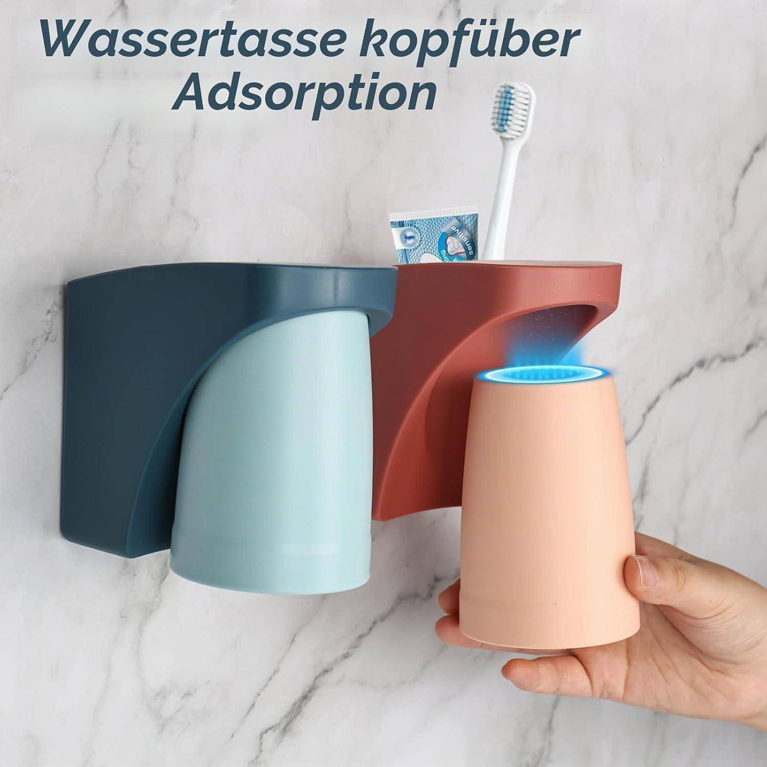Klebender wandmontierter Badezimmerhalter für einen umgestülpten Becher, mit einem Zahnbürsenplatz und einer Hand, die einen Becher in den Spender einführt.