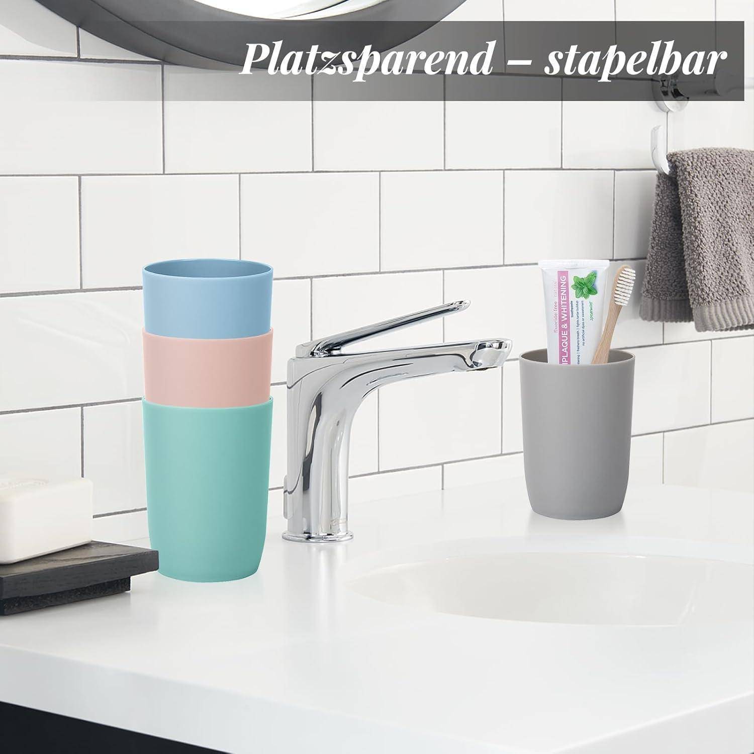 Badezimmerwaschbereich mit stapelbaren Bechern auf der linken Seite und einem Zahnbürstenhalter auf der rechten Seite; der Text lautet „Platzsparend – stapelbar