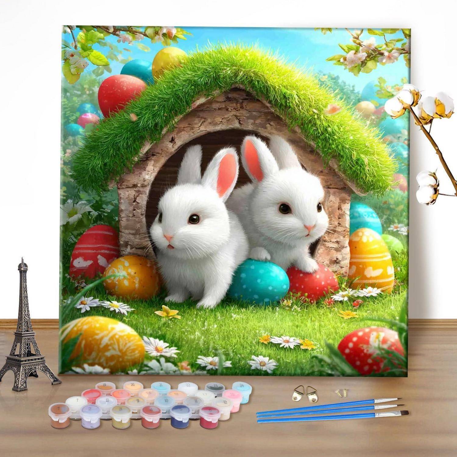 Zwei weiße Kaninchen sitzen in einem grasbewachsenen Bau, der mit Ostereiern dekoriert ist, was auf eine Frühlings- oder Feiertagsmalszene hindeutet.