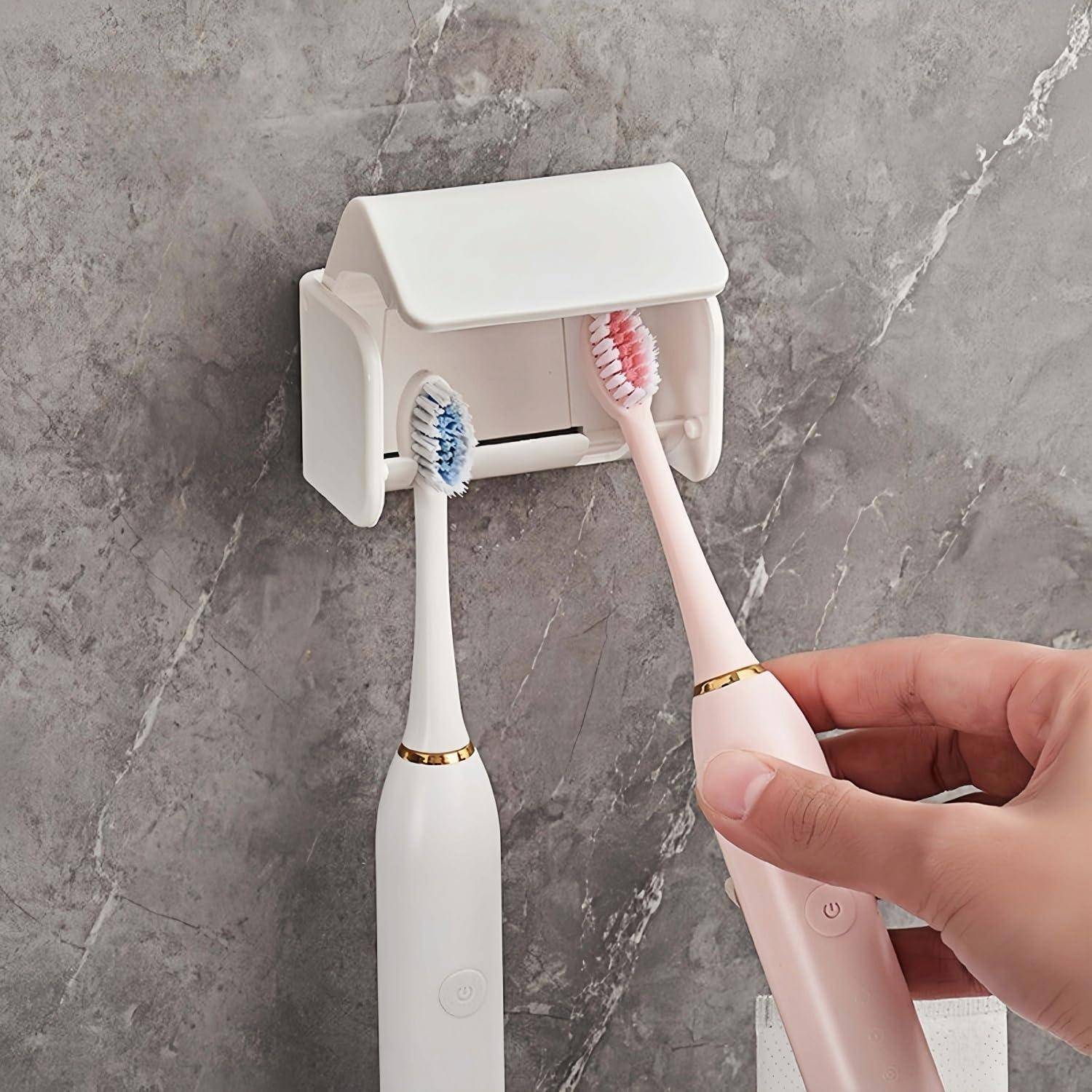 Hand, die eine rosa elektrische Zahnbürste in einen wandmontierten UV-Ladegerät neben einer weißen Zahnbürste, die bereits darin gelagert ist, einführt.