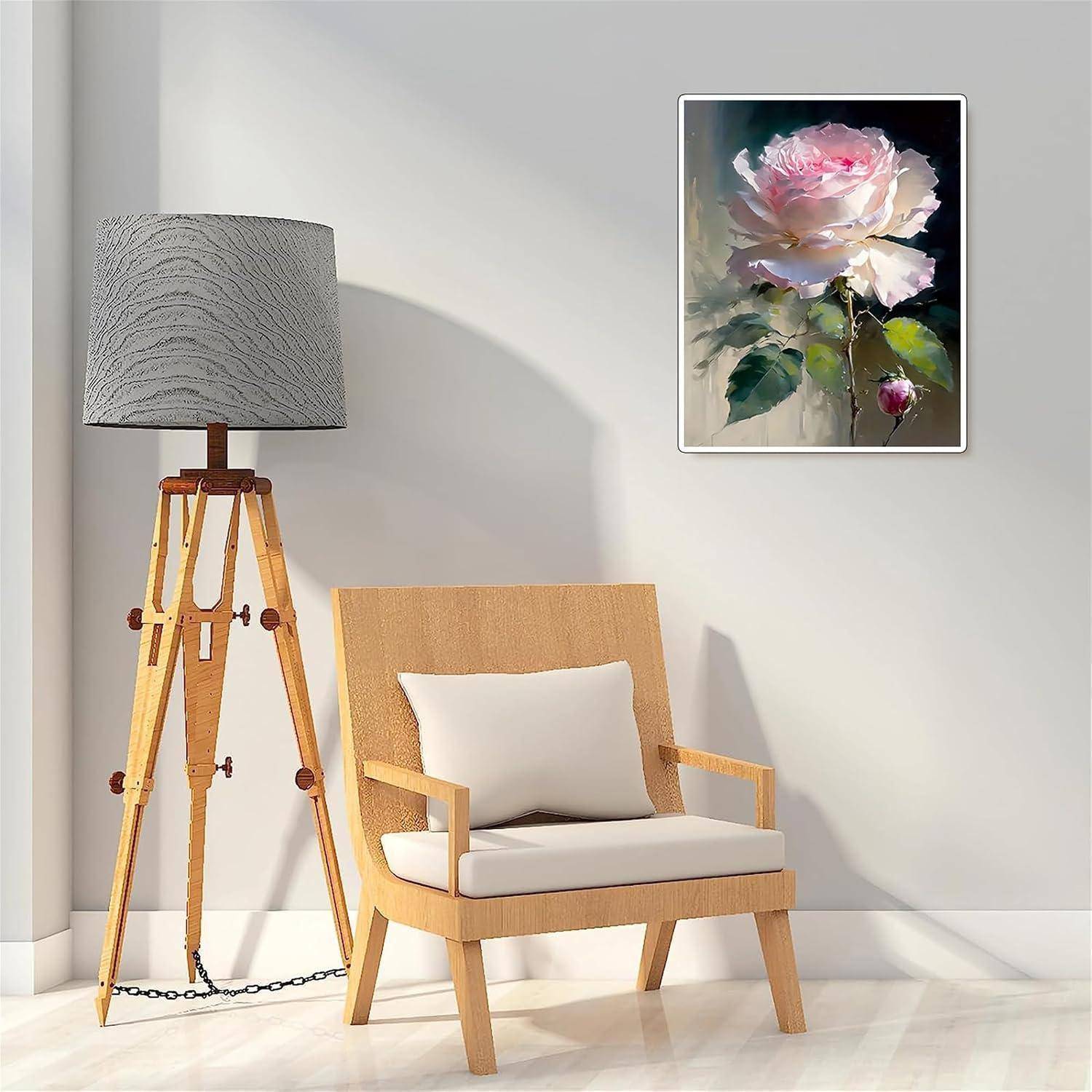 Modernes Rauminterieur mit einer Stativstehleuchte, einem gepolsterten Holzsessel und einem gerahmten rosa Blumengemälde an einer weißen Wand.