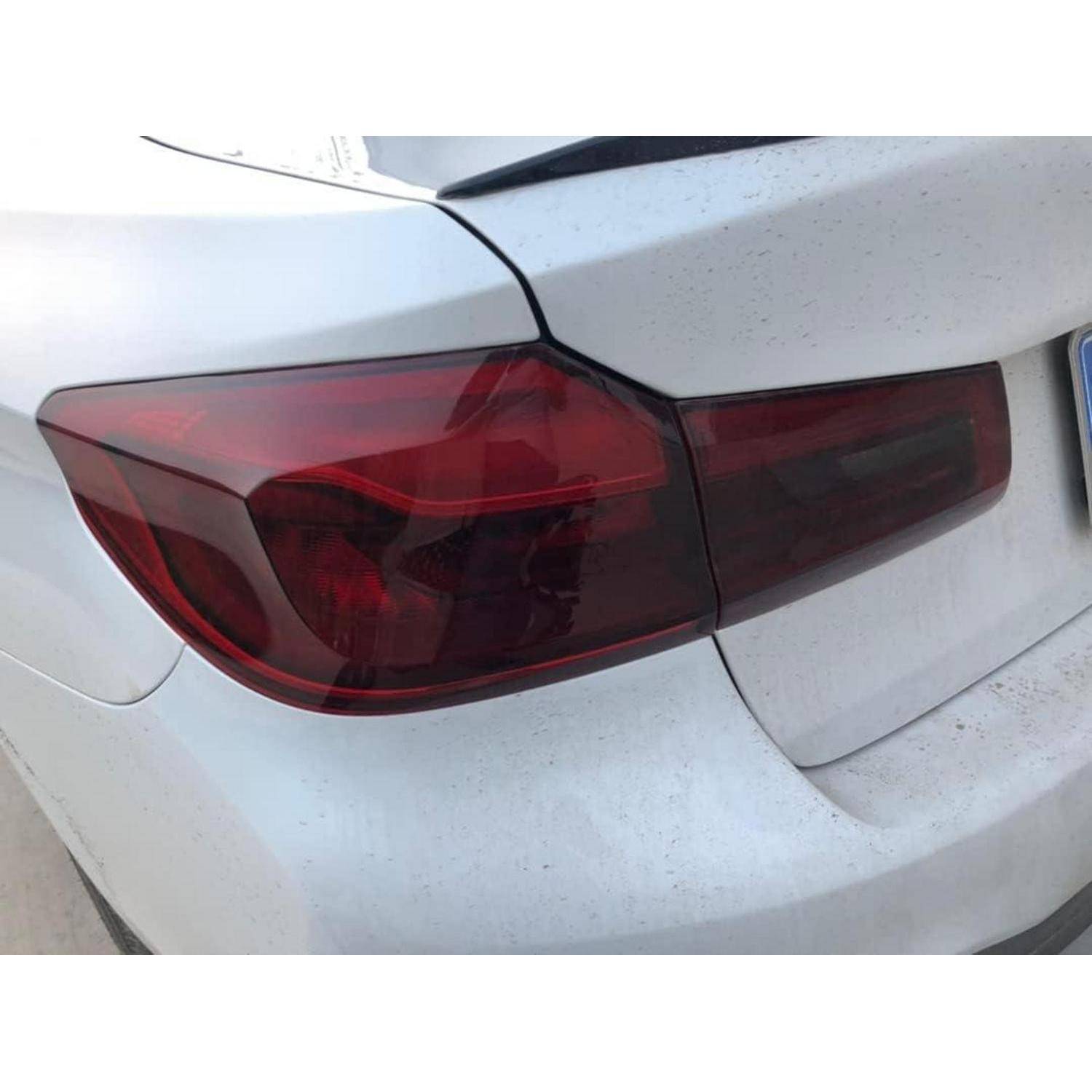 Nahaufnahme des hinteren linken Rücklichts eines weißen Autos und der Kofferraumnaht, zeigt rote Lichtlinse mit leichtem Schmutz auf der Stoßstange.