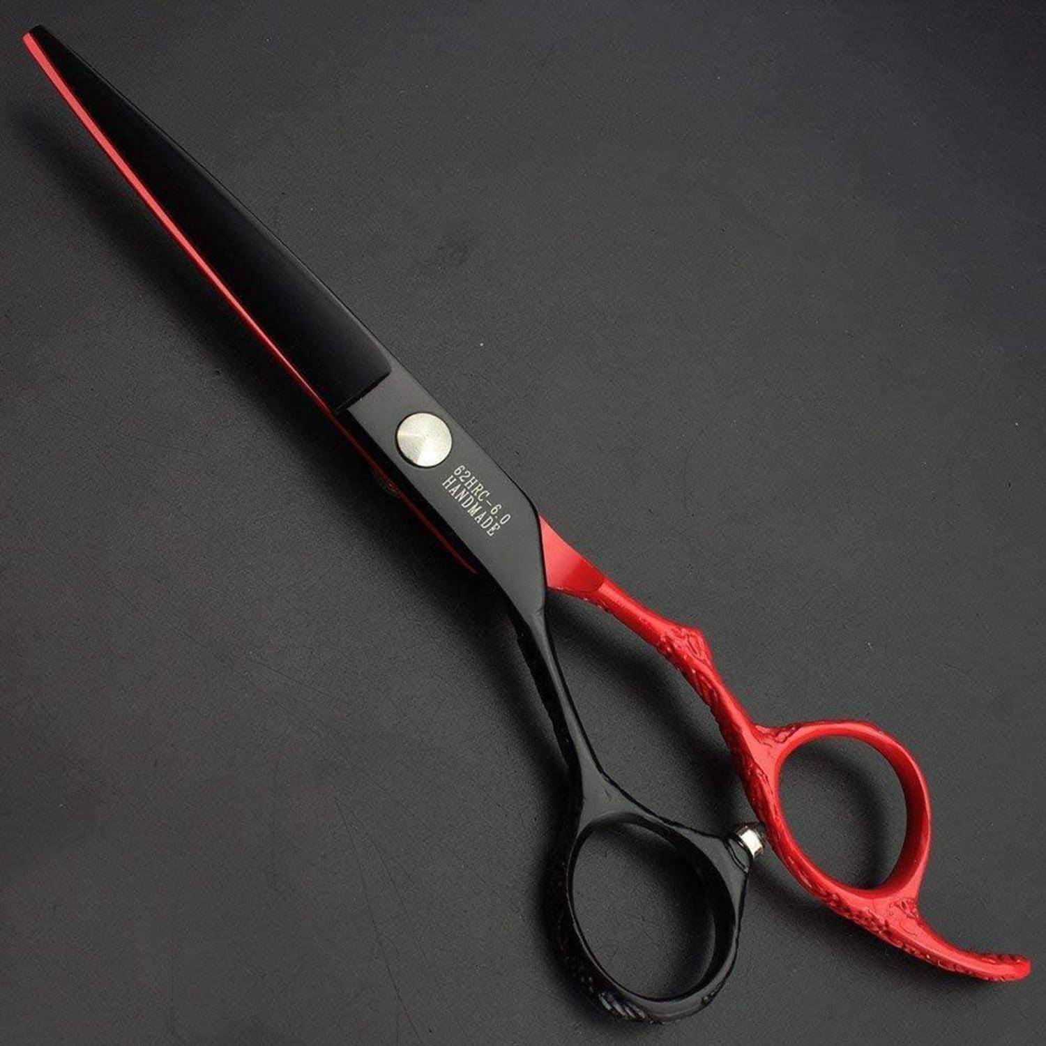 Schwarze und rote Friseurscheren mit langen Klingen und Fingeröffnungen auf dunklem Hintergrund.