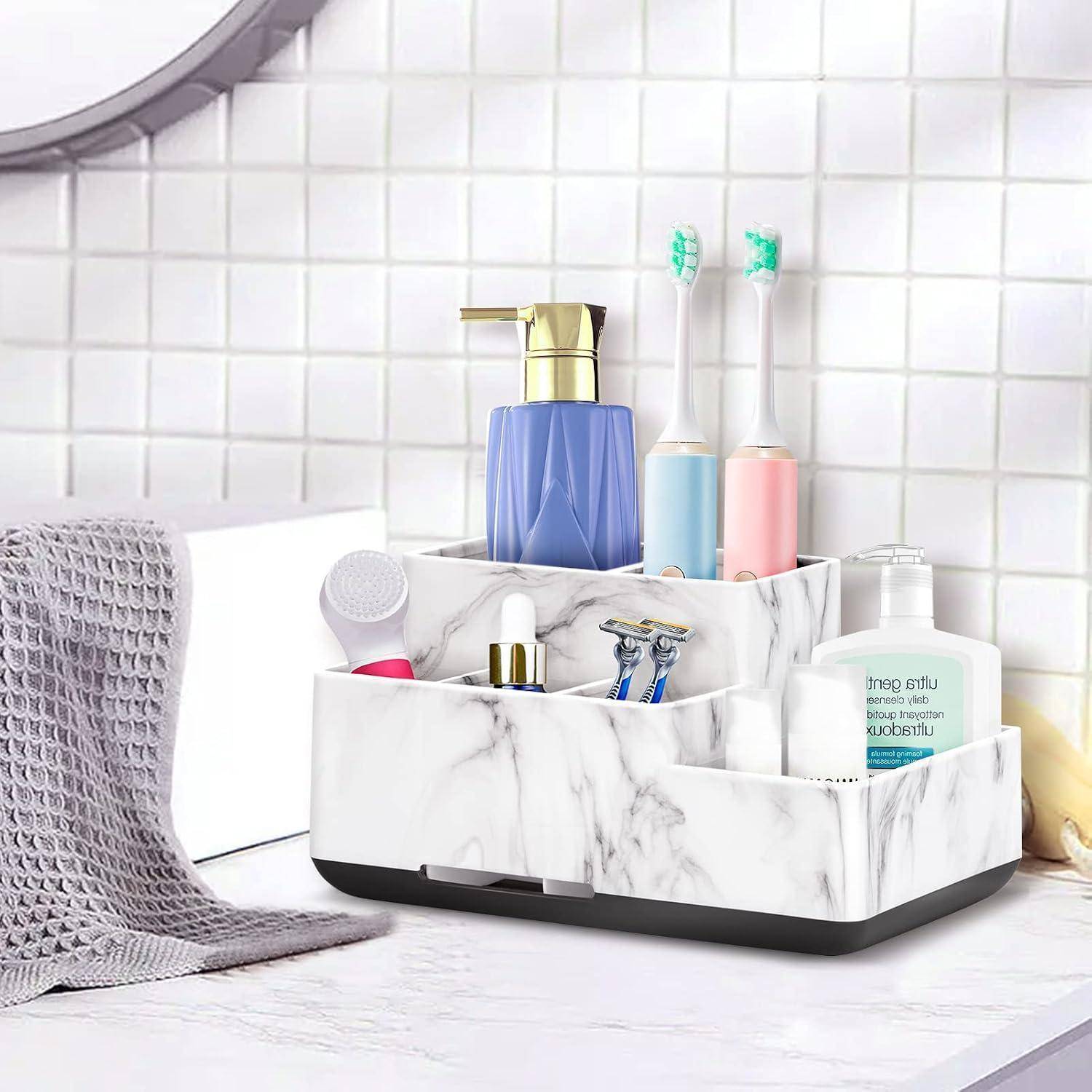 Badezimmer-Organizer mit Marmoroptik, der Zahnpasta, Rasierer, Zahnbürsten, Seifenspender und andere Toilettenartikel auf einer Waschtischplatte hält.