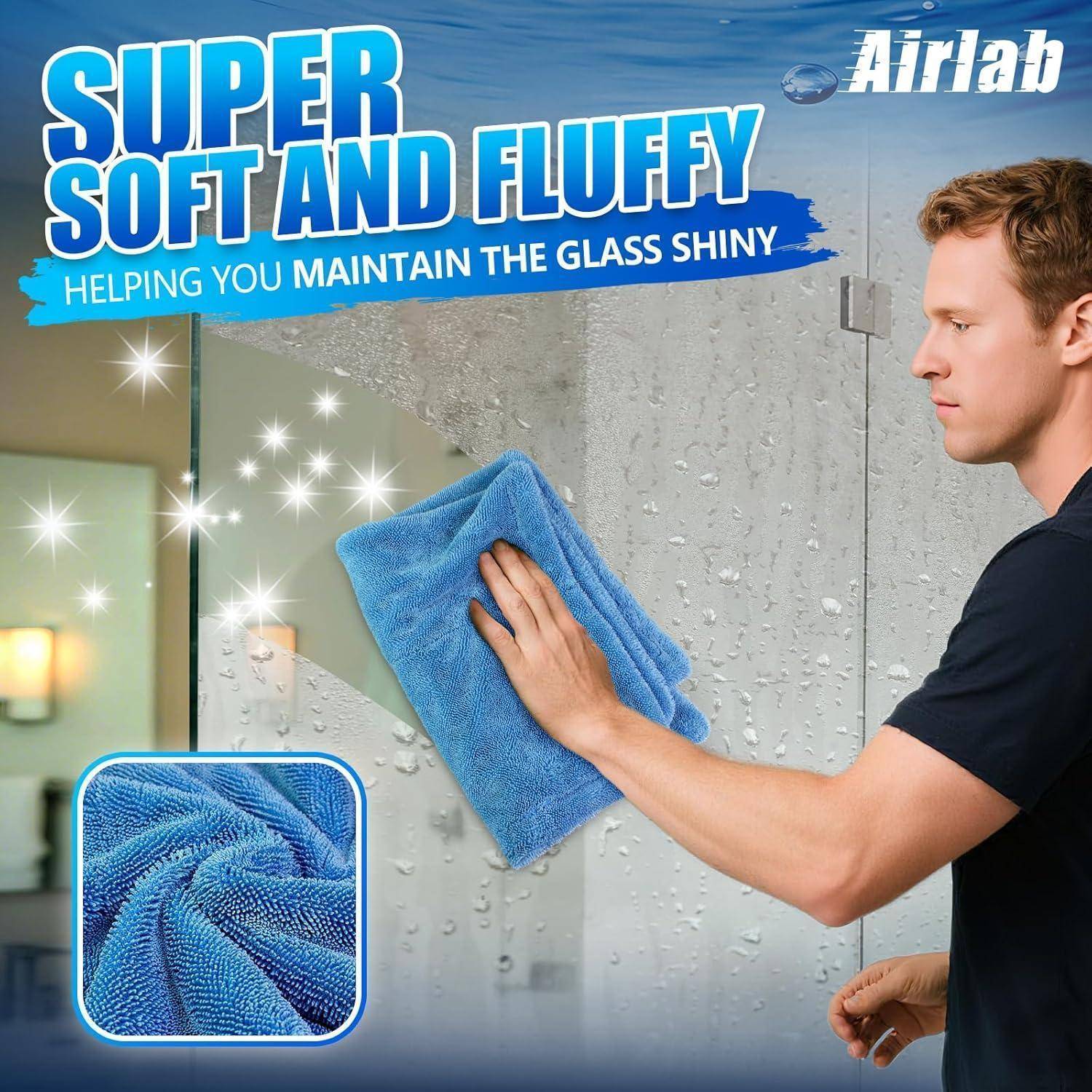 Ein Mann putzt eine Glasschiebetür der Dusche mit einem blauen Mikrofasertuch; der Anzeigentext besagt „SUPER WEICH UND FLAUSCHIG